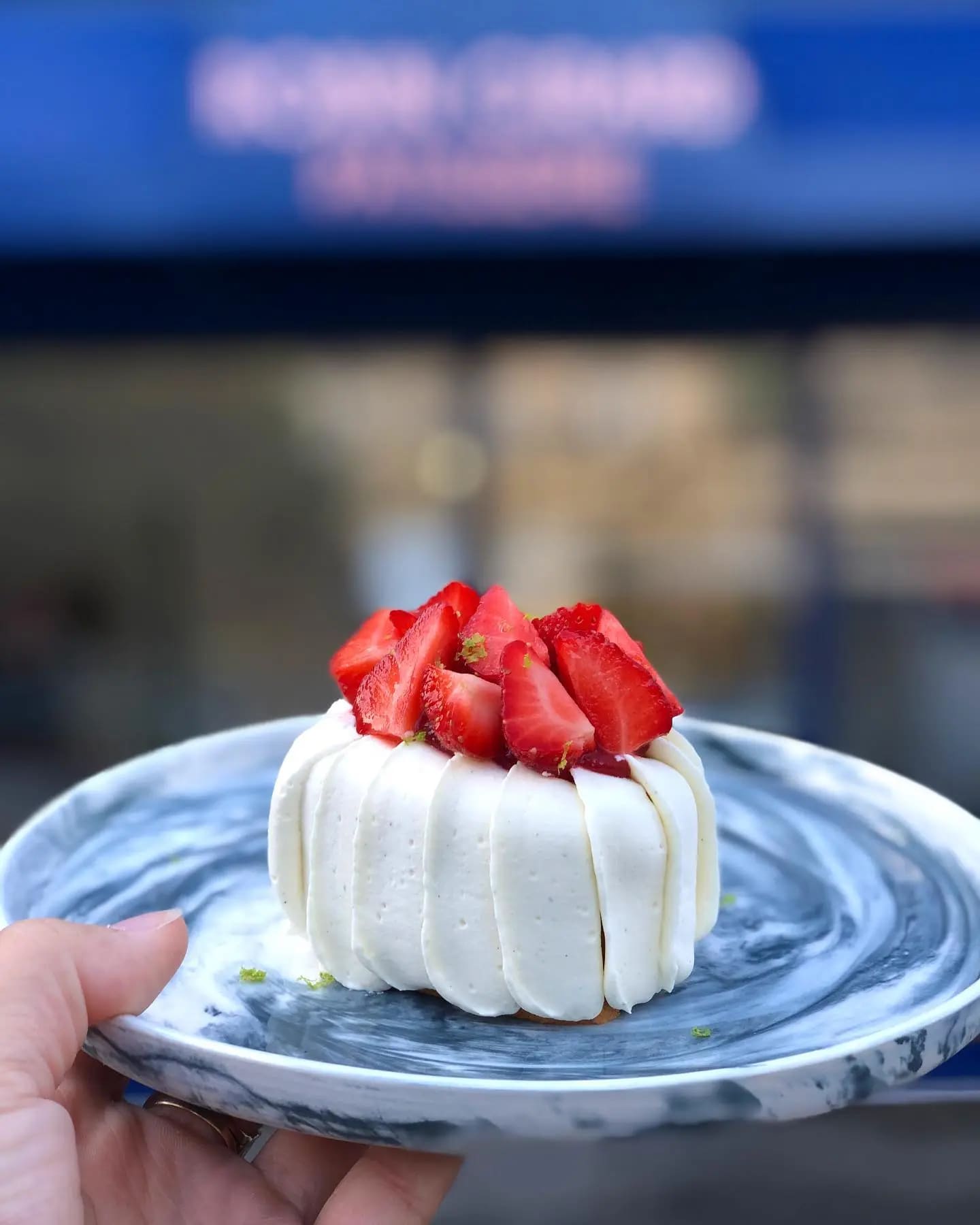un délicieux fraisier dans une jolie assiette devant Robin Girard Pâtisserie