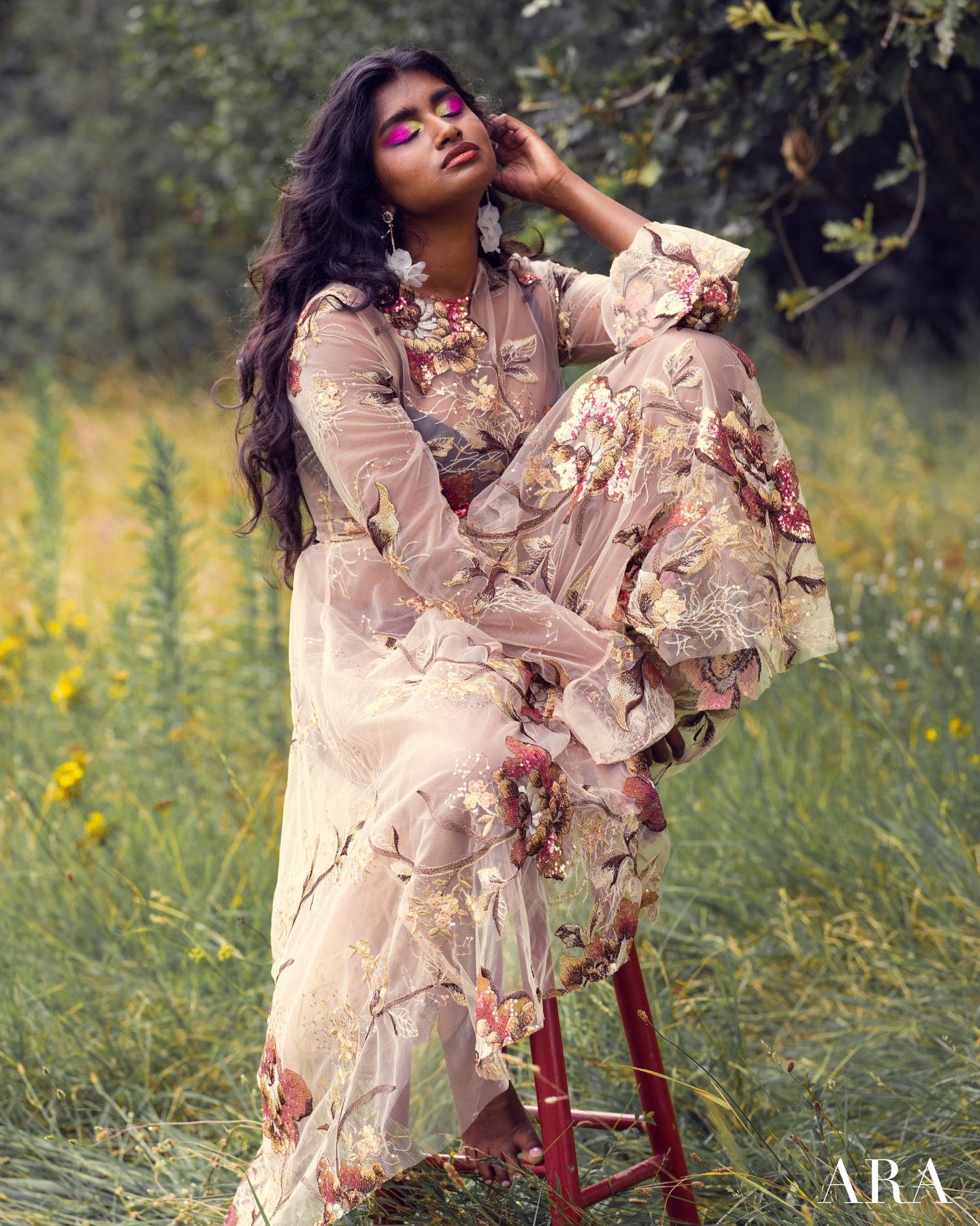 Une femme vêtue d’une robe à fleurs Anaïs Ricard assise sur une chaise 