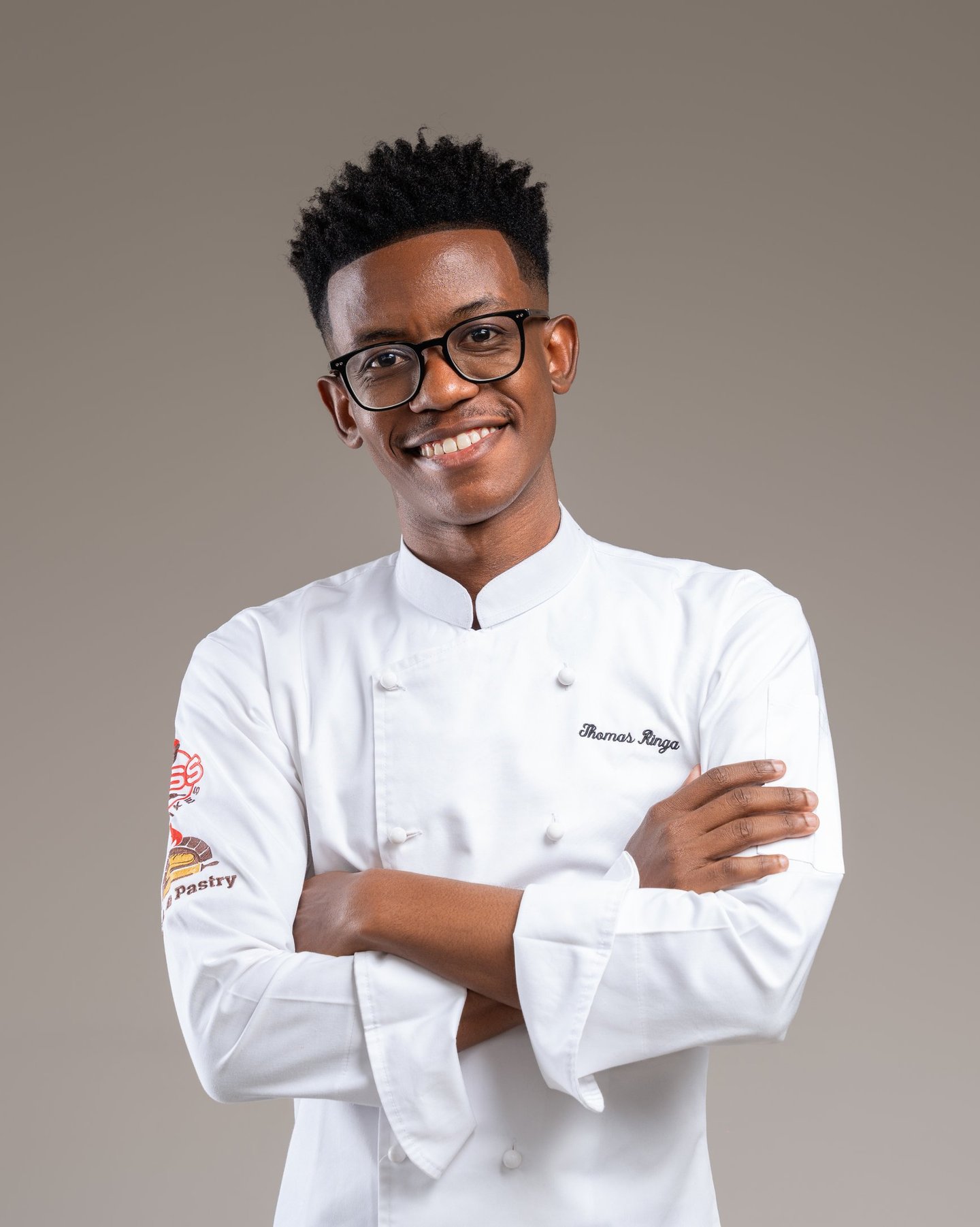 a man in a chef's uniform and glasses