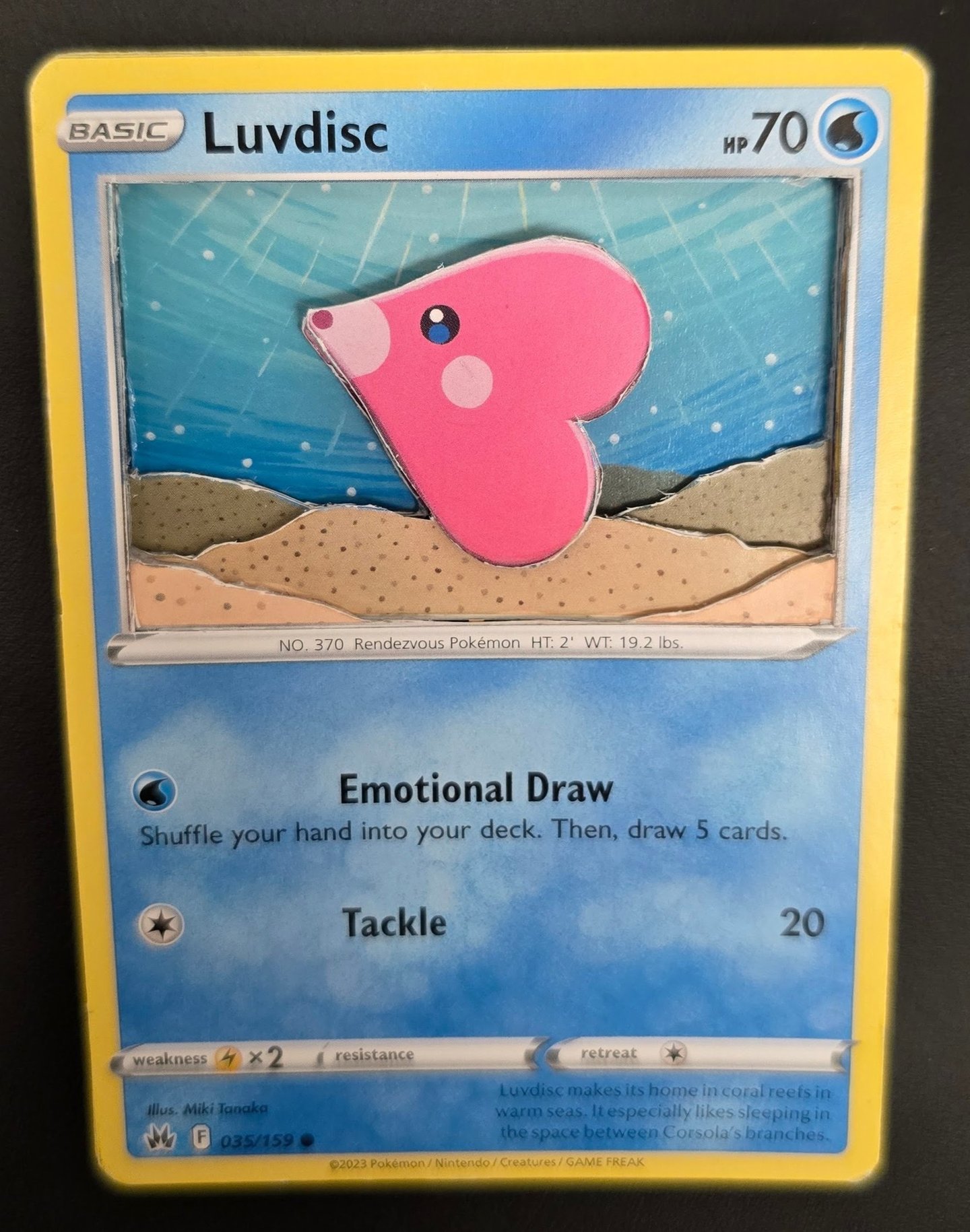 A 3D shadowbox paper craft of a pink Luvdisc Pokémon card with layered underwater scenery.
