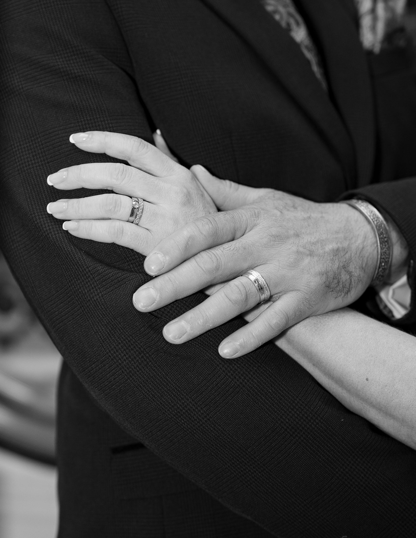 black and white image of hands with wedding rings