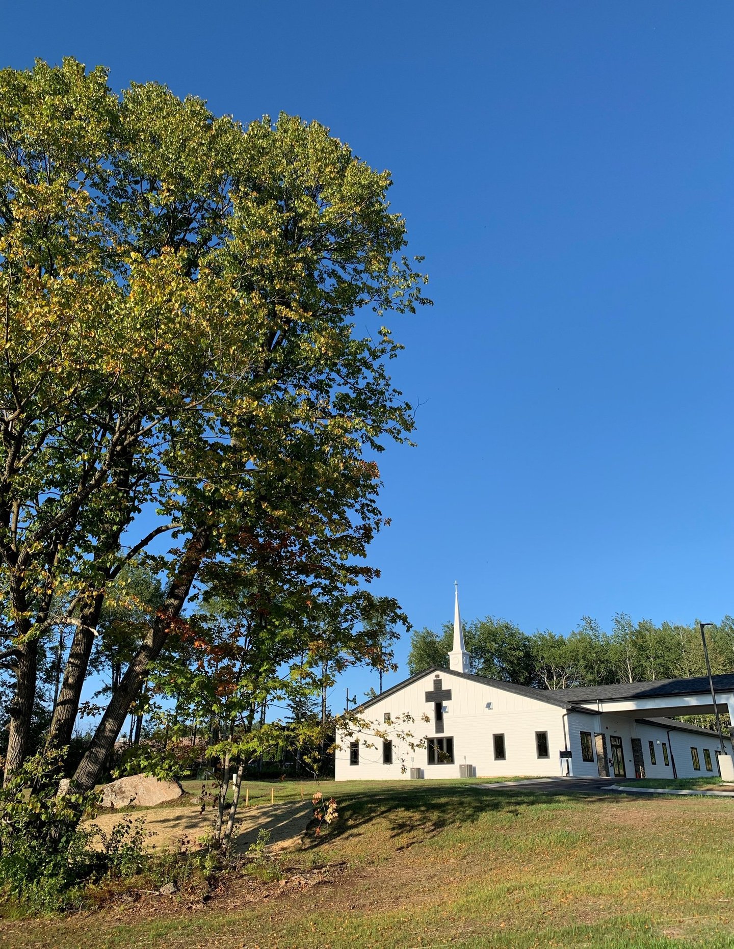 New Life Lutheran church building, steeple, and tree