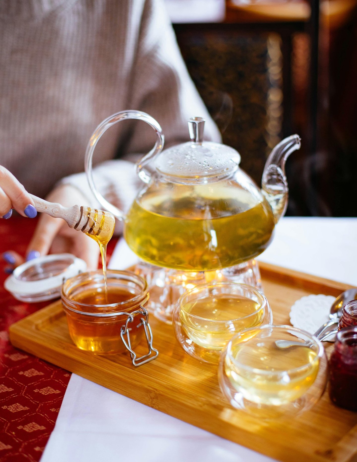 a person pouring tea into a teapot