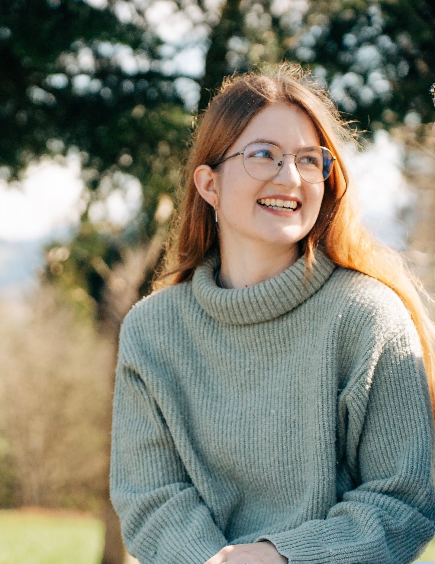 Svenja Ricchiuti, Grafikerin bei SRdesign, draussen sitzend.