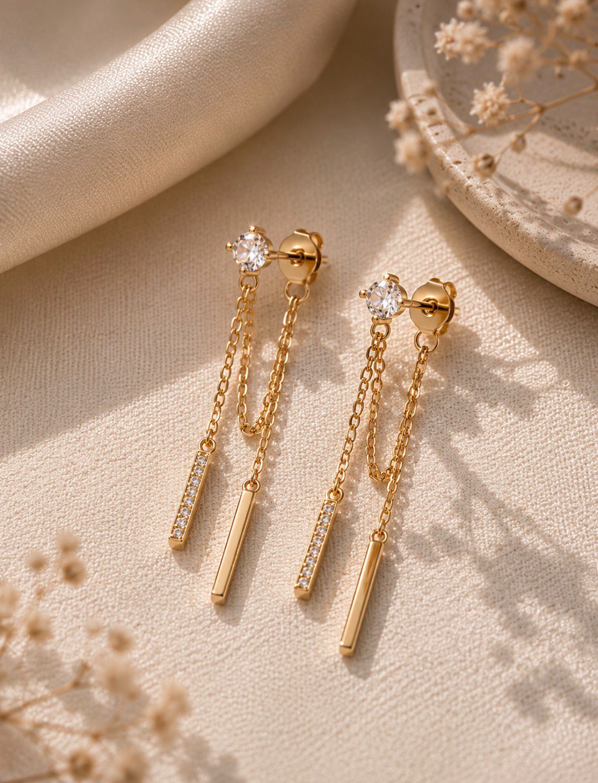 Close-up of gold chain drop earrings with sparkling details.