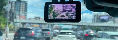 A car dash cam mounted on a windshield recording heavy city traffic for safety and evidence.
