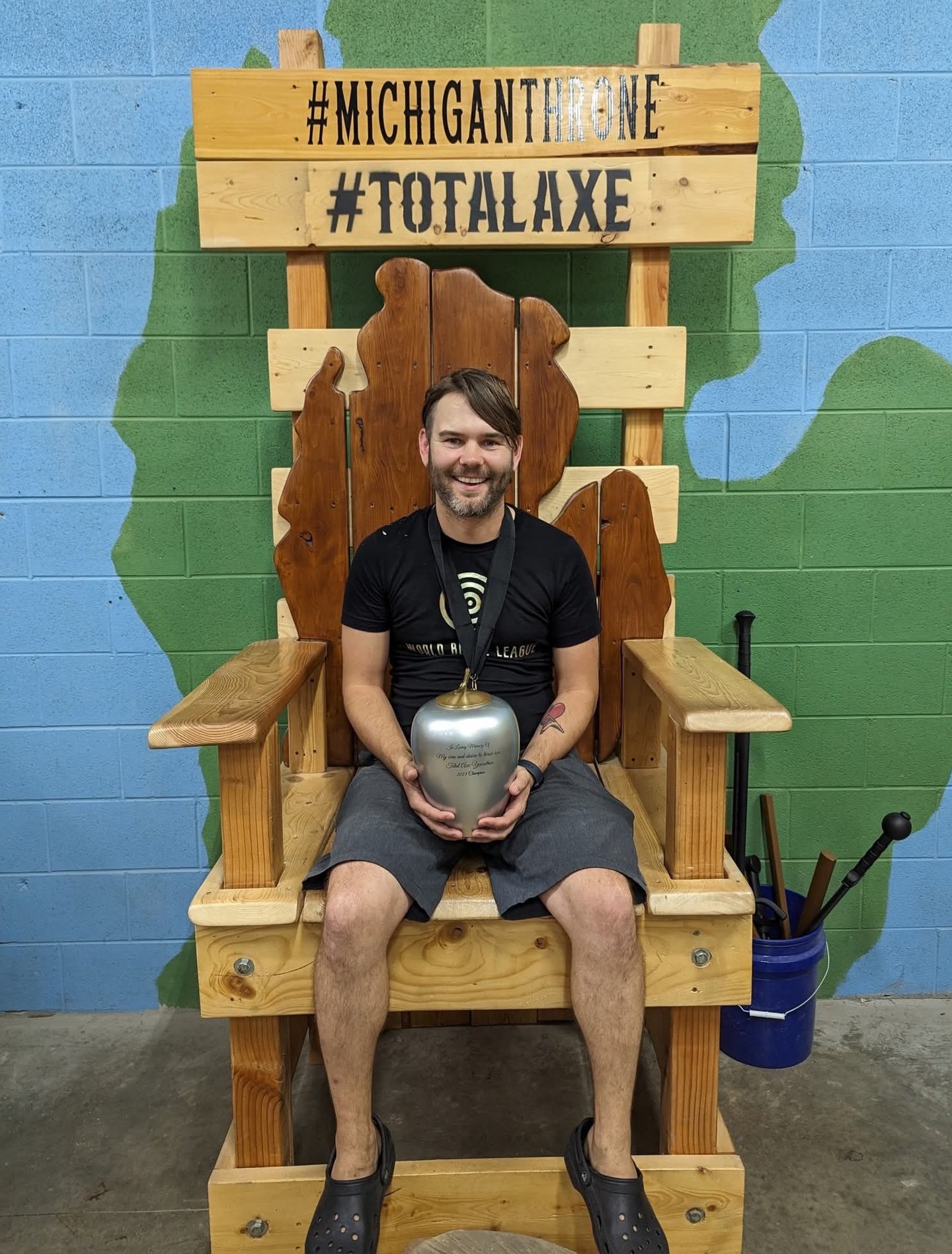 man sitting on a throne holding a trophy