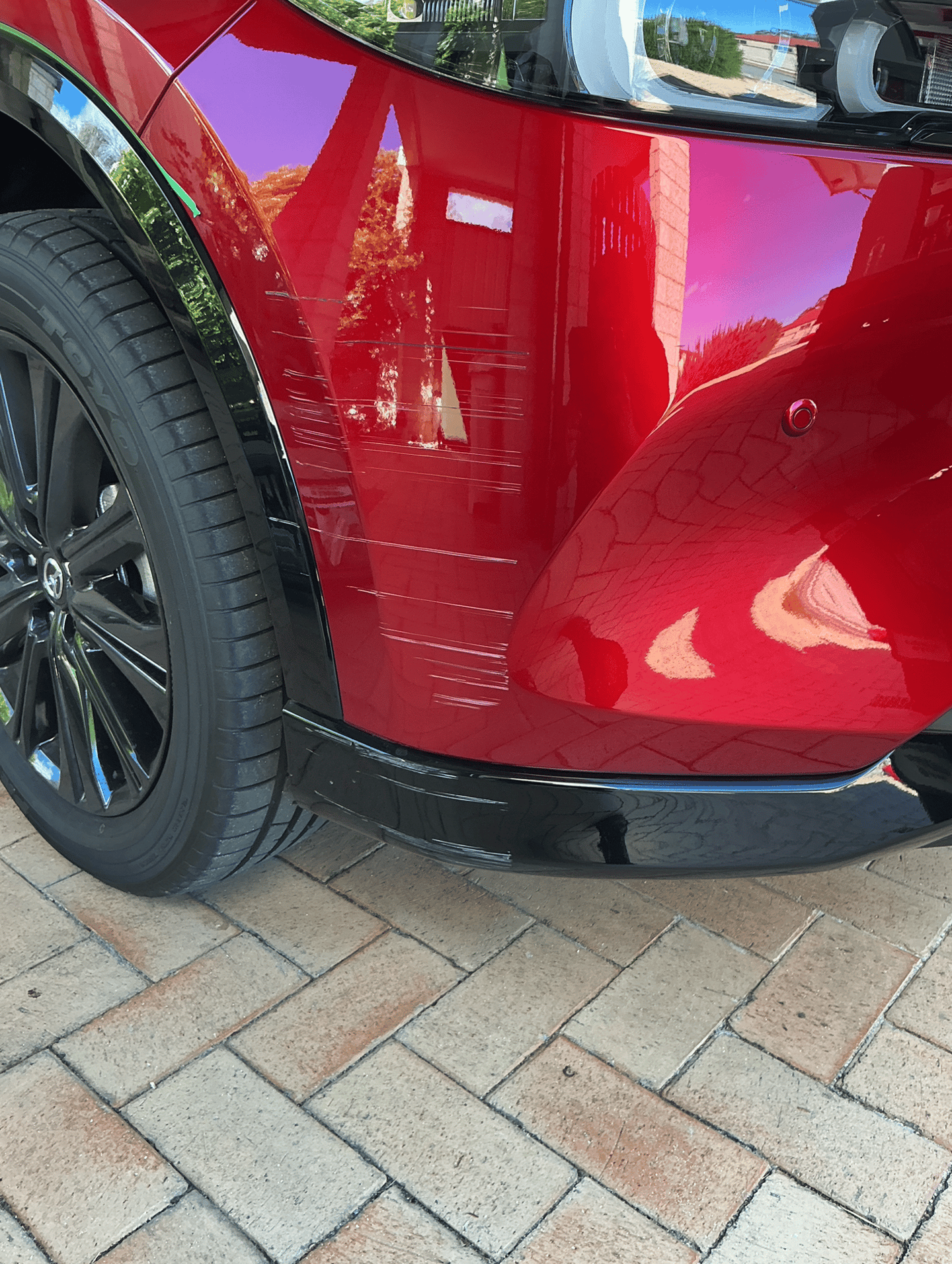 Scratches and paint damage on the front bumper of a red Mazda before scratch repair Perth
