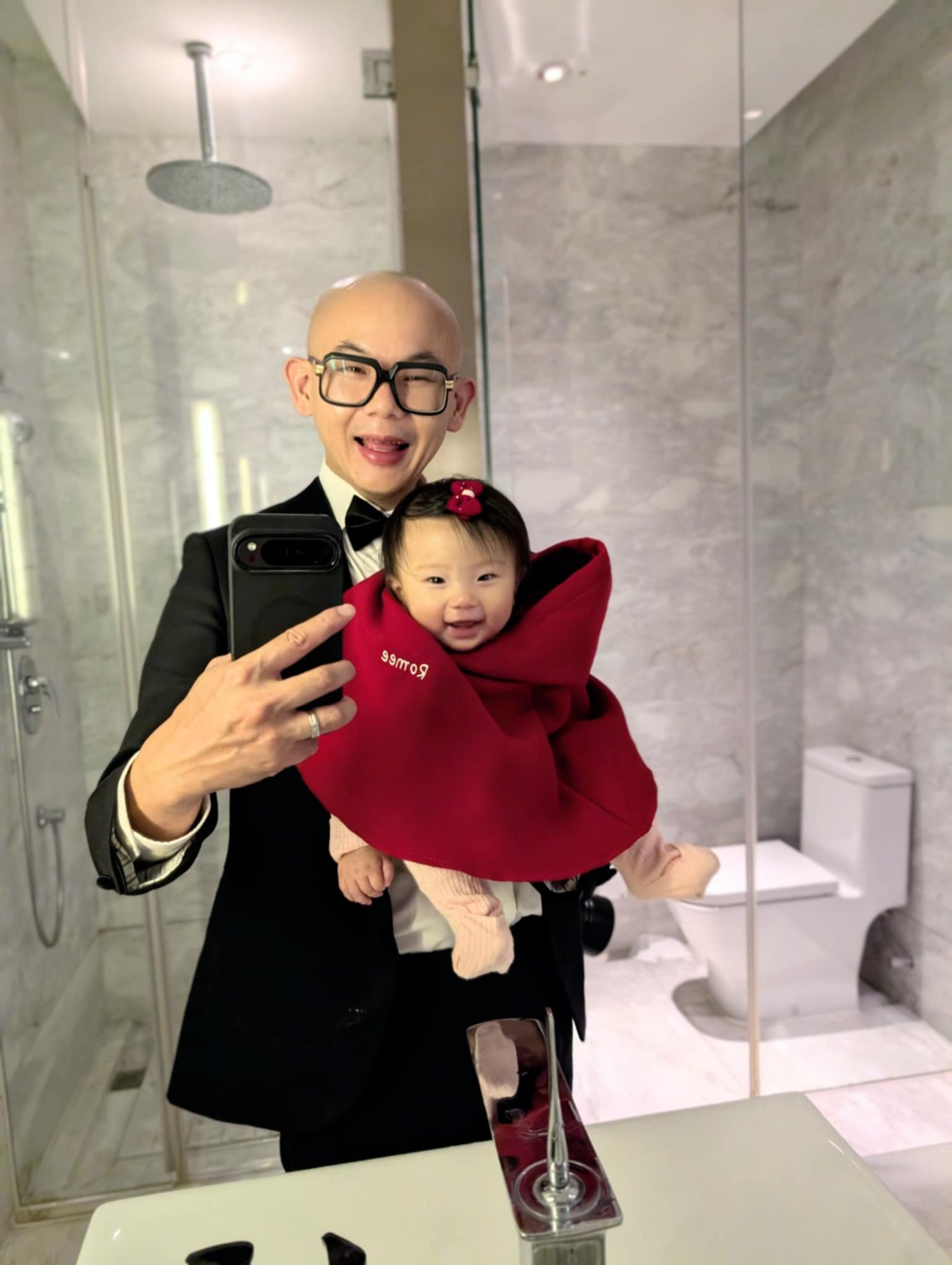 a man in a suit and tie is taking a selfie with his baby