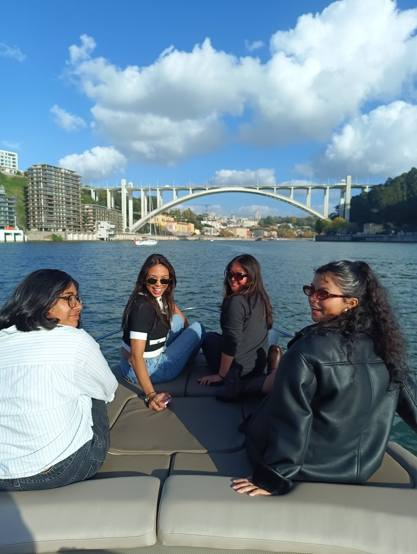 Enjoying a scenic private boat tour on the Douro River in Porto with Arrabida Bridge in background.
