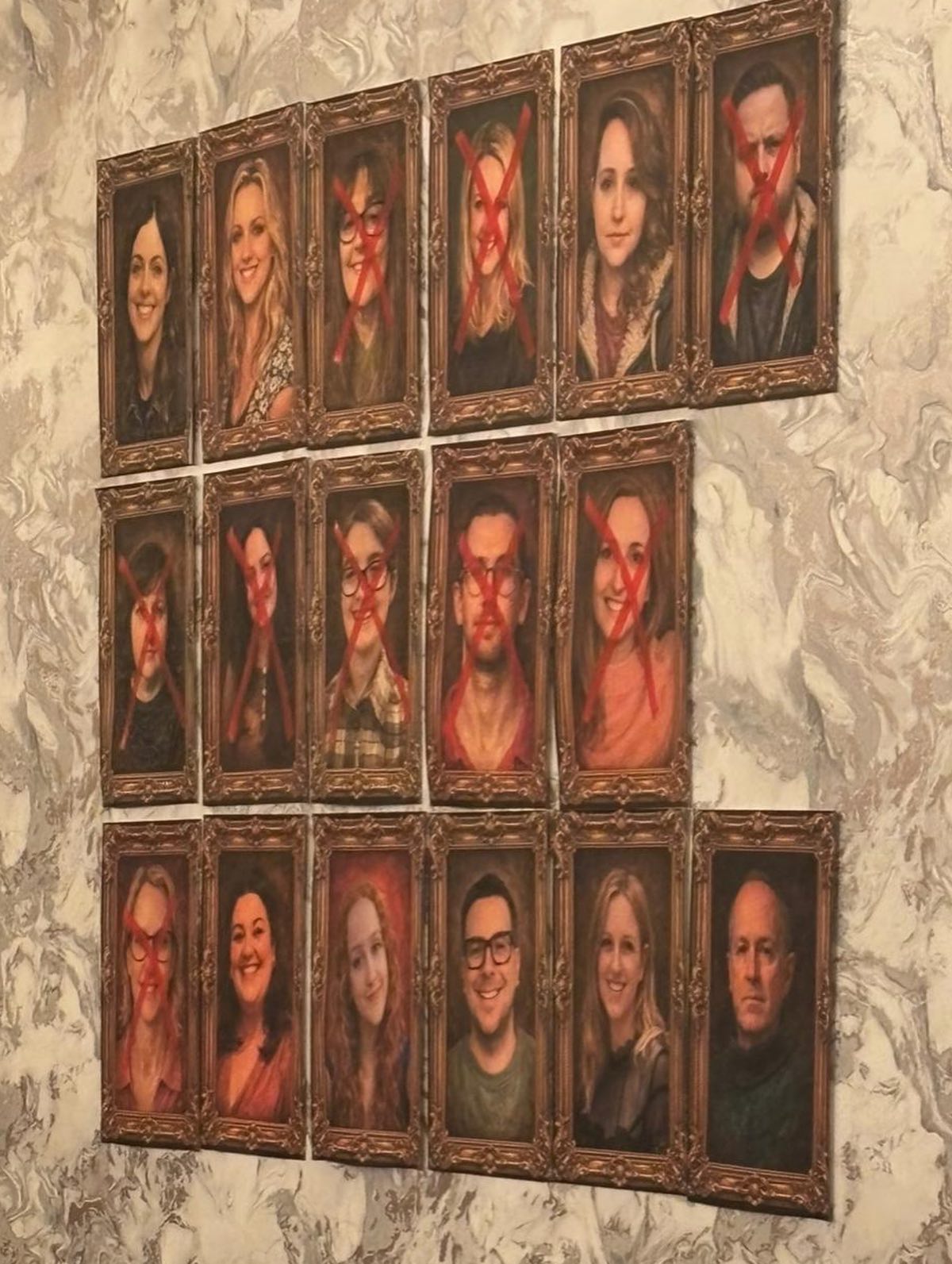 pictures of people in portrait frames. some have their faces crossed out with a red X. Traitors night.