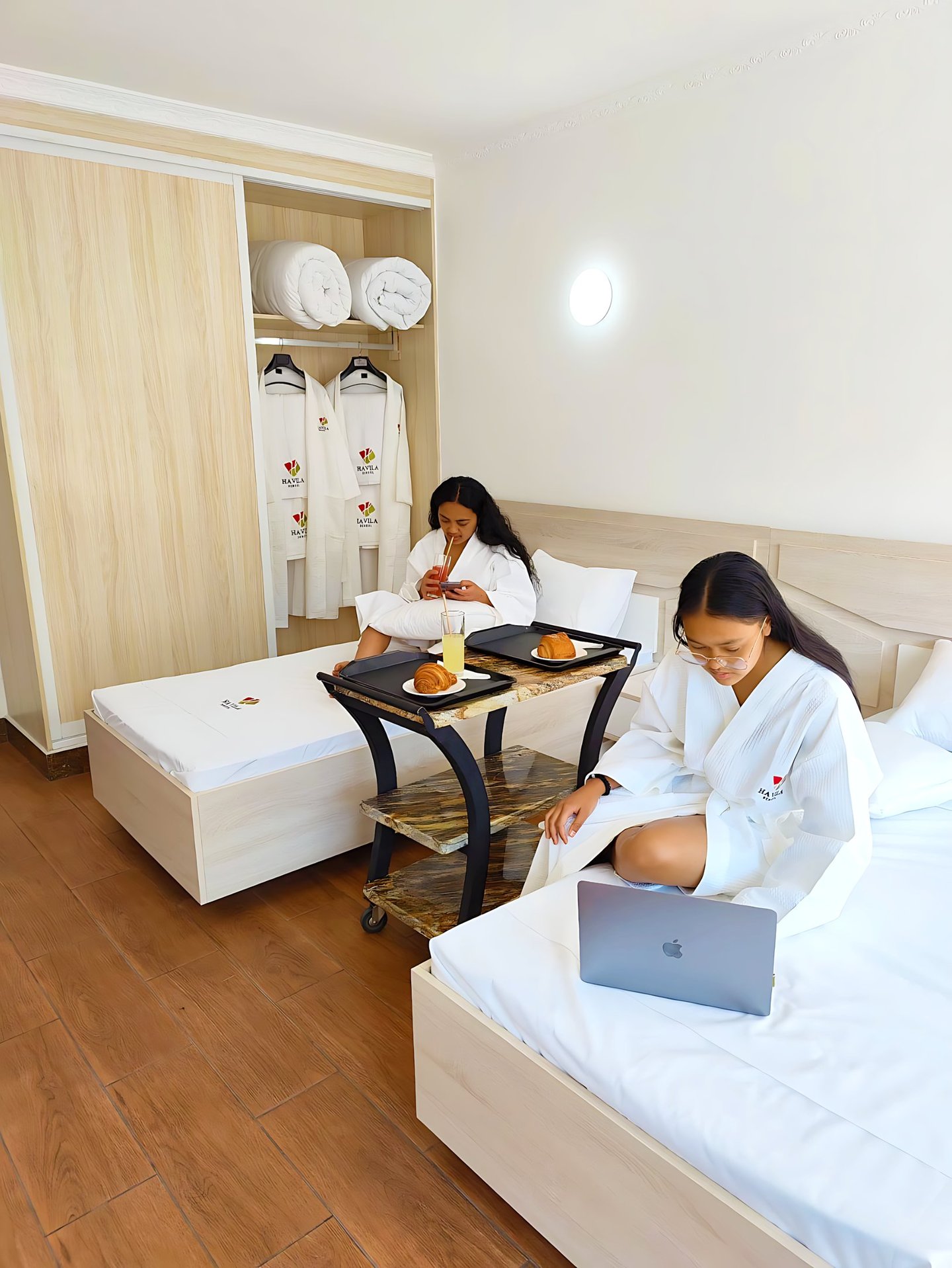a woman sitting on a bed with a laptop computer
