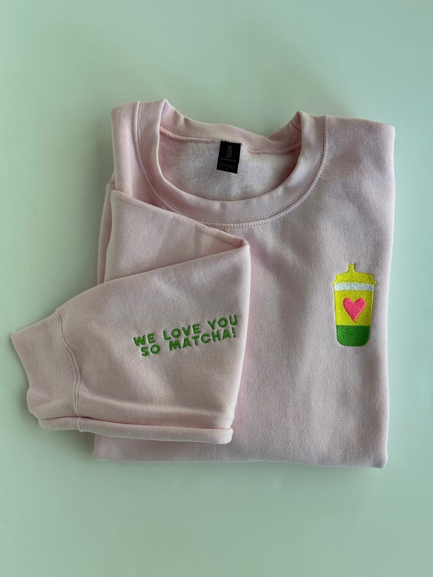 pink sweatshirt with a cup of matcha embroidered on it
