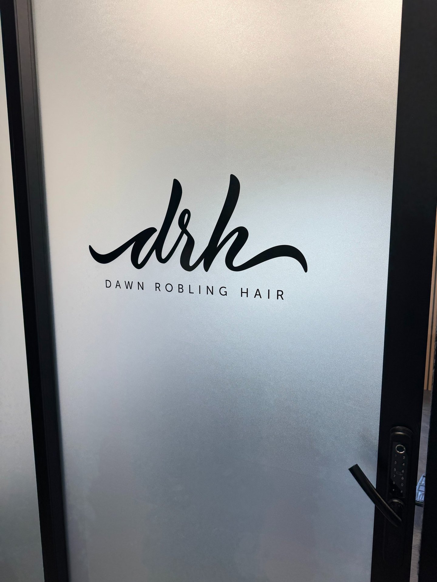 Frosted glass door with custom black Dawn Robling Hair logo decal installed by Big Sticker