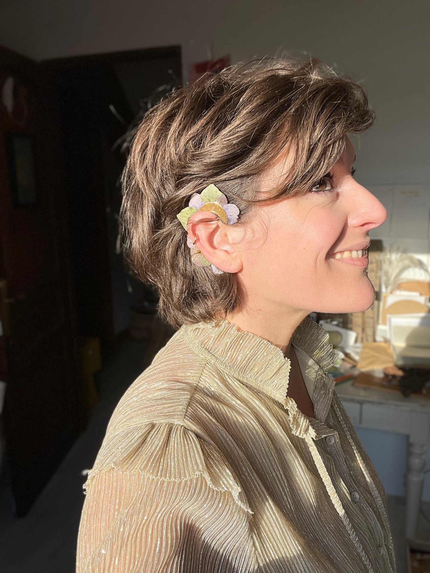 portrait de la créatrice Charlie O'Plumes portant un earcuff en pétales d'hortensia dans son atelier