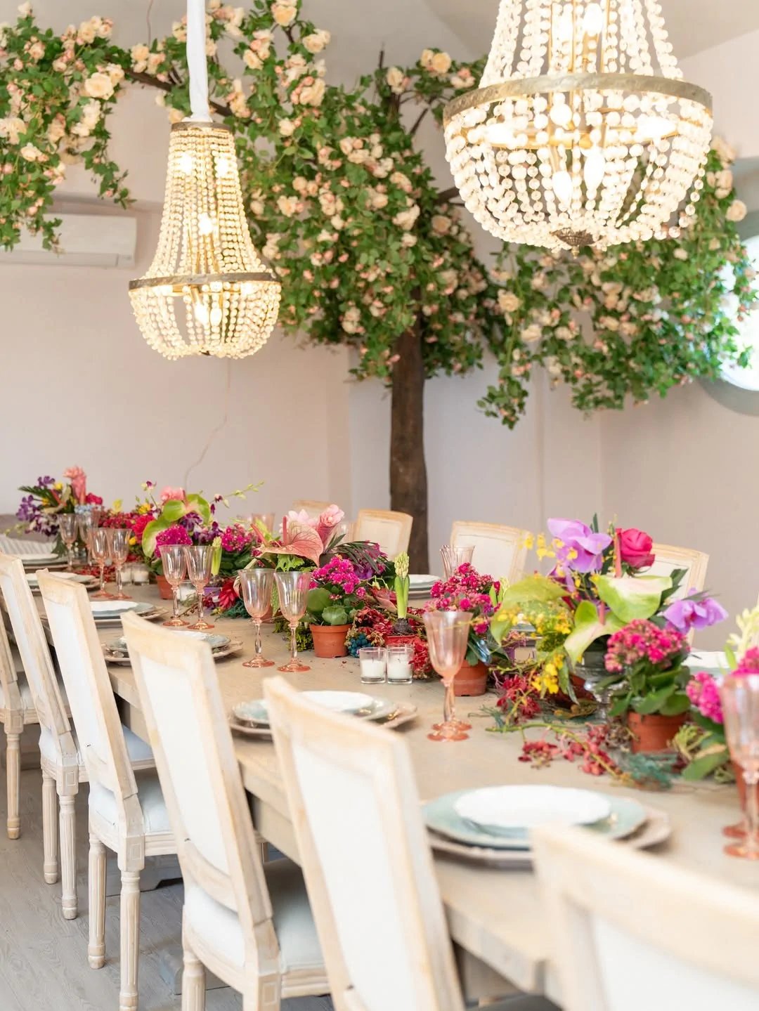 Long banquet table with floral centerpiece and chandeliers