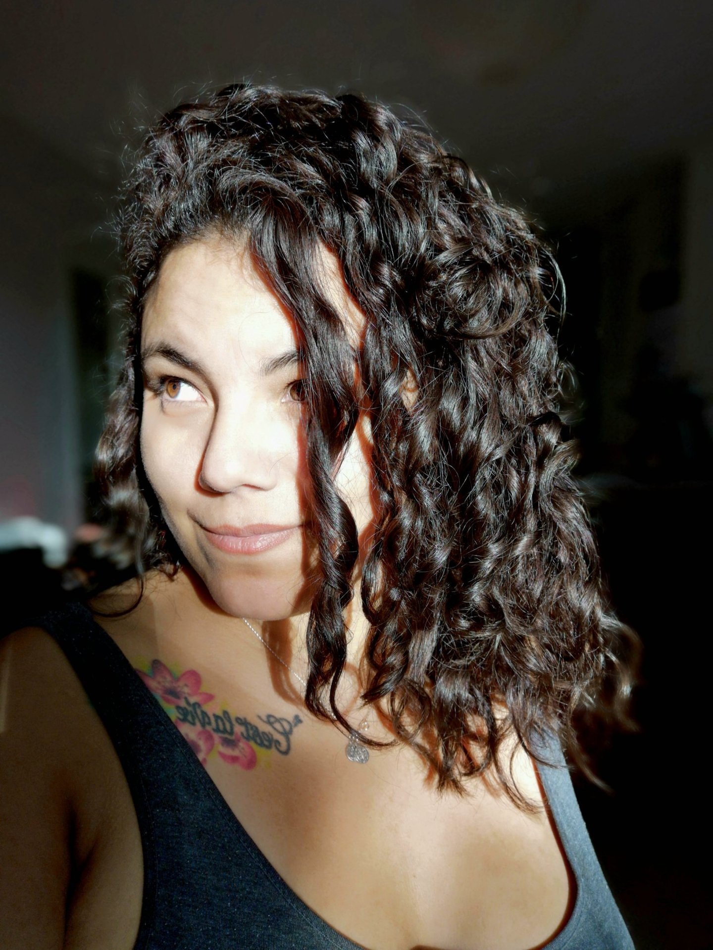 Portrait de Suzi Santana, regard éveillé et tatouage de rose, symbole de reconnaissance intuitive