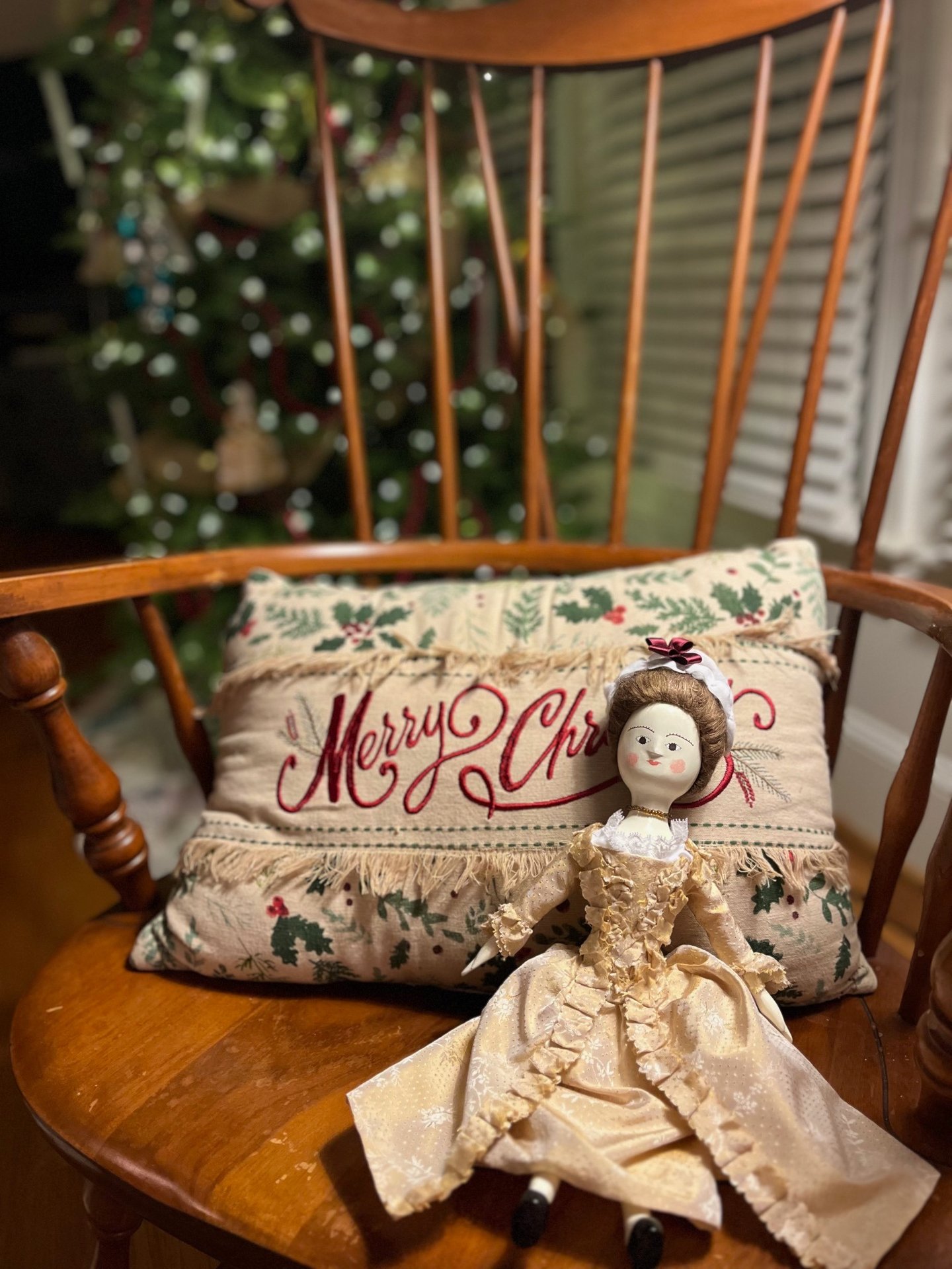 a doll doll sitting on a rocking chair