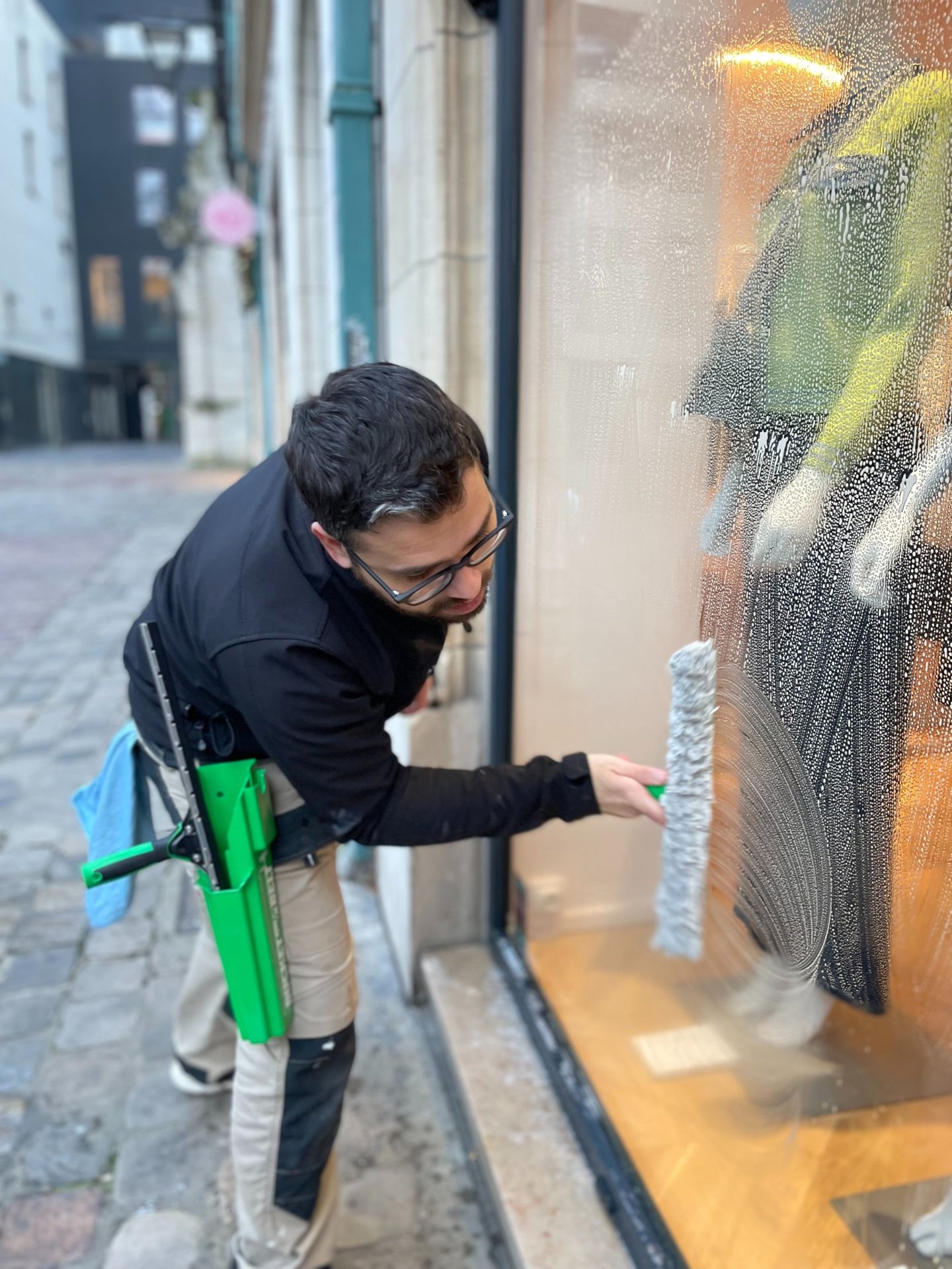 Technicien de M & M Services Pro nettoyant la vitrine du magasin Léo et Ugo à Rouen