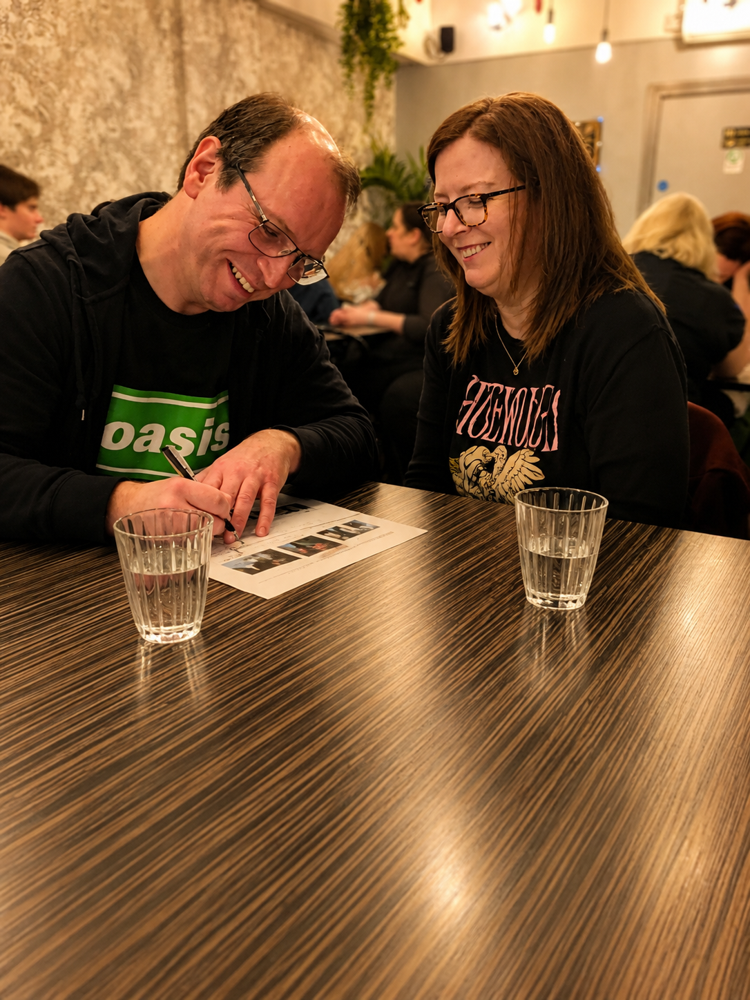 a man and a woman enjoy themselves at a quiz.
