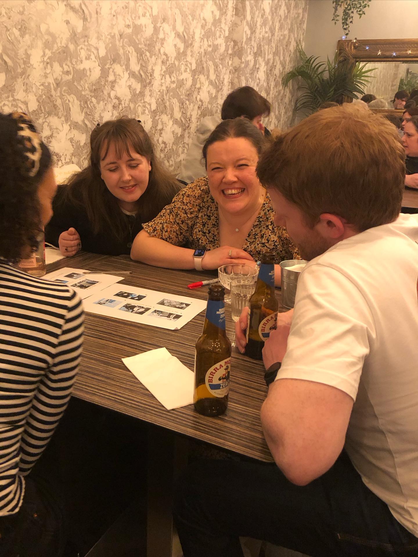 Girl enjoying herself at a quiz night with friends.