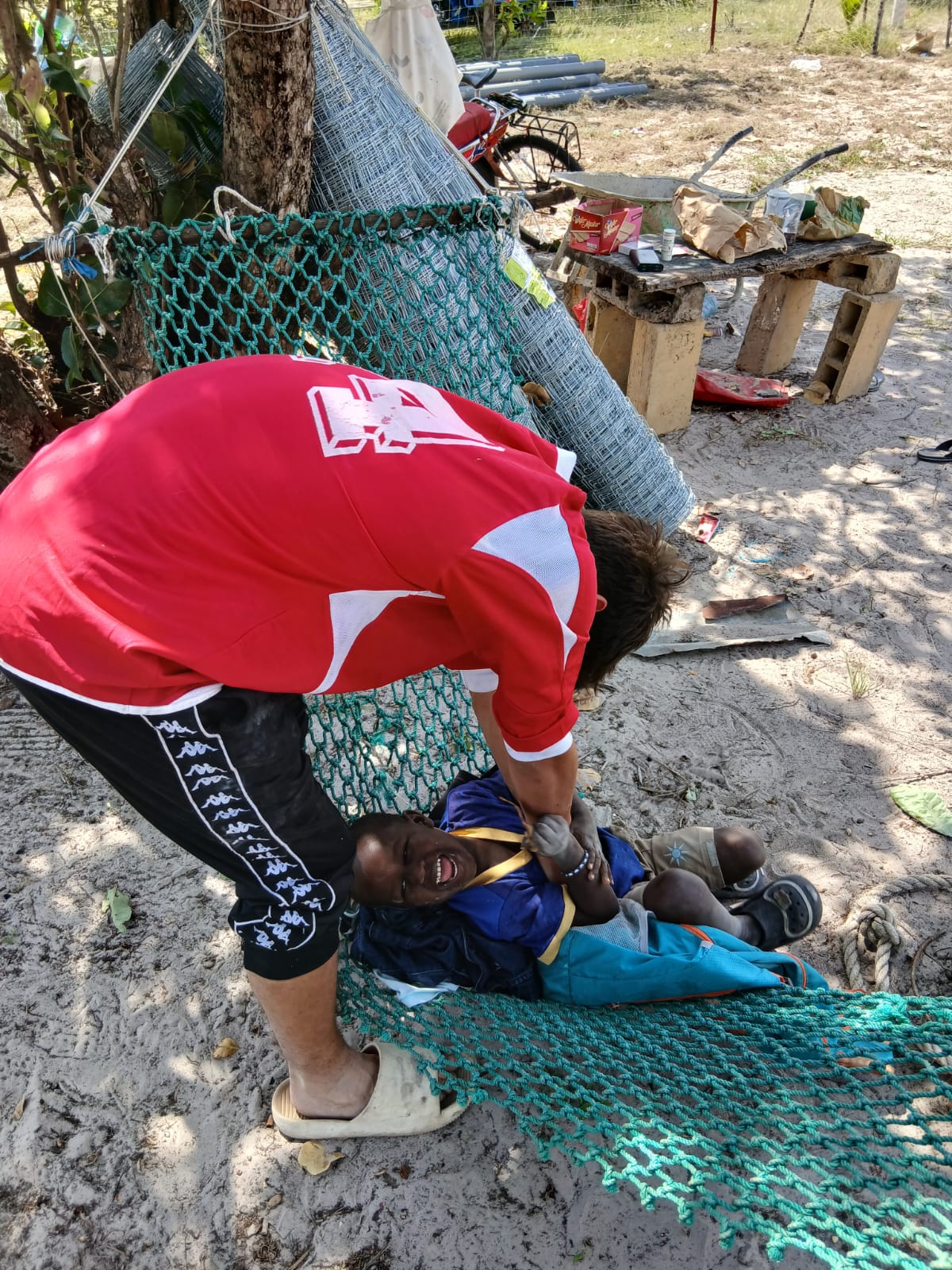 Photo d'un jeune accompagné par Bourokk et Kadiamor qui s'amuse avec le petit Modou