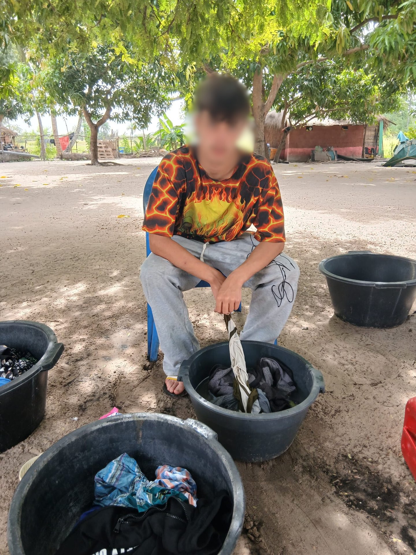 Photo d'un jeune accompagné par Bourokk et Kadiamor qui s'occupe de laver son linge à la main