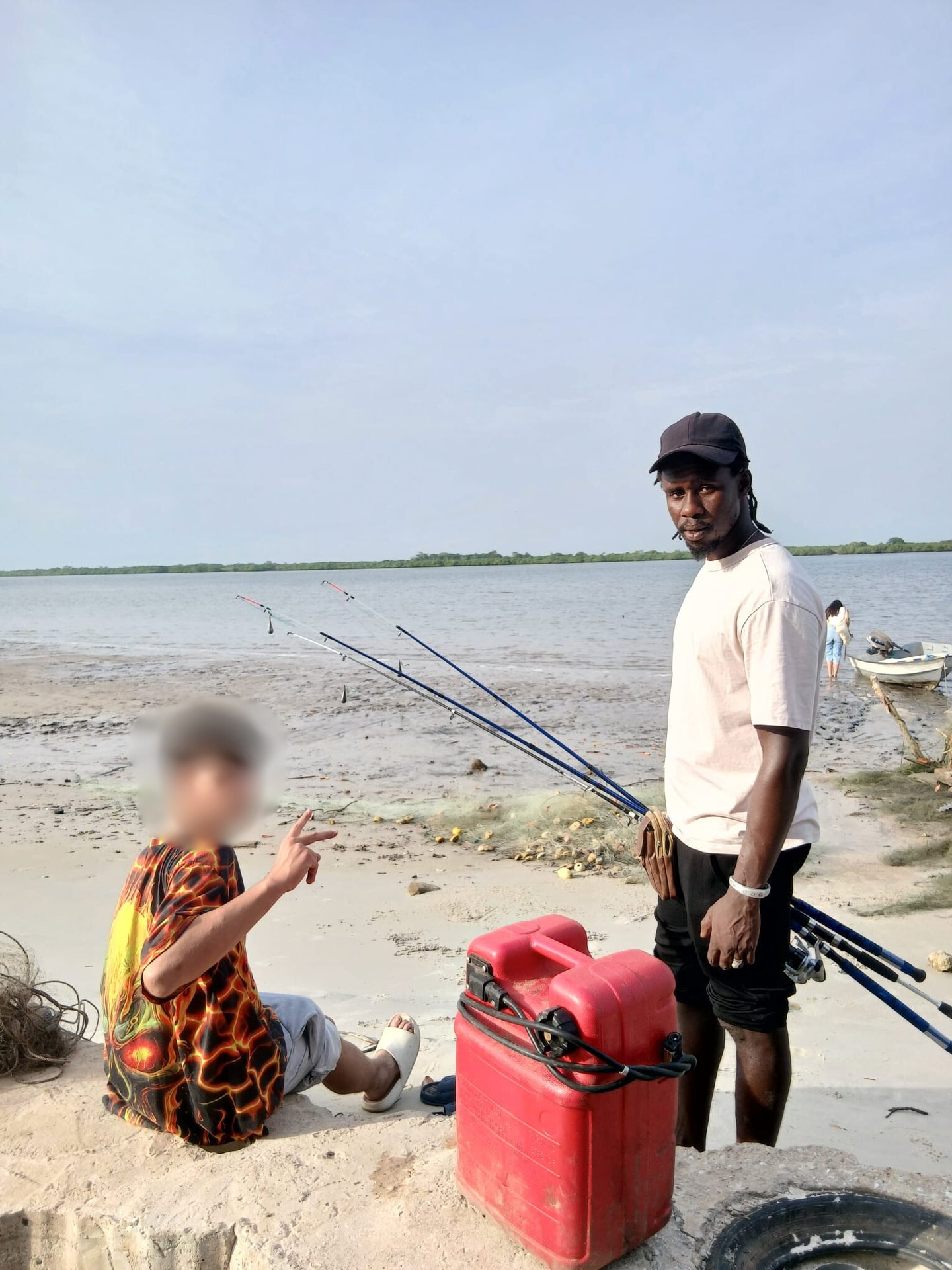 Photo d'un jeune accompagné par Kadiamor et Bourokk qui apprend à pêcher