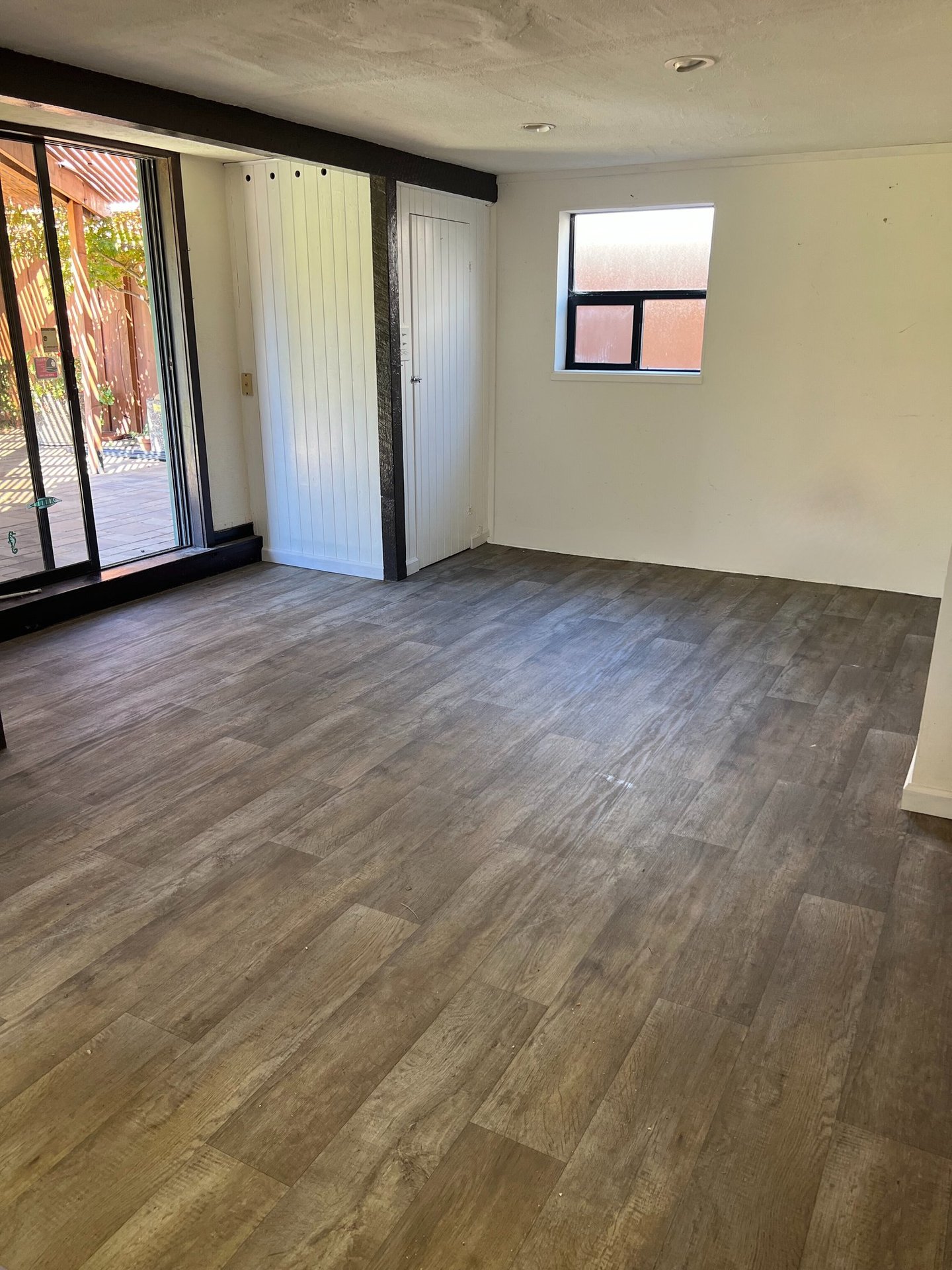 a living room with a large window and a sliding glass door