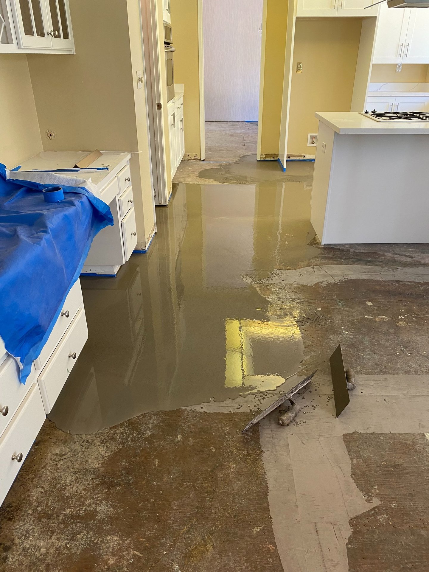 a kitchen floor with a blue tarp and a blue tarp