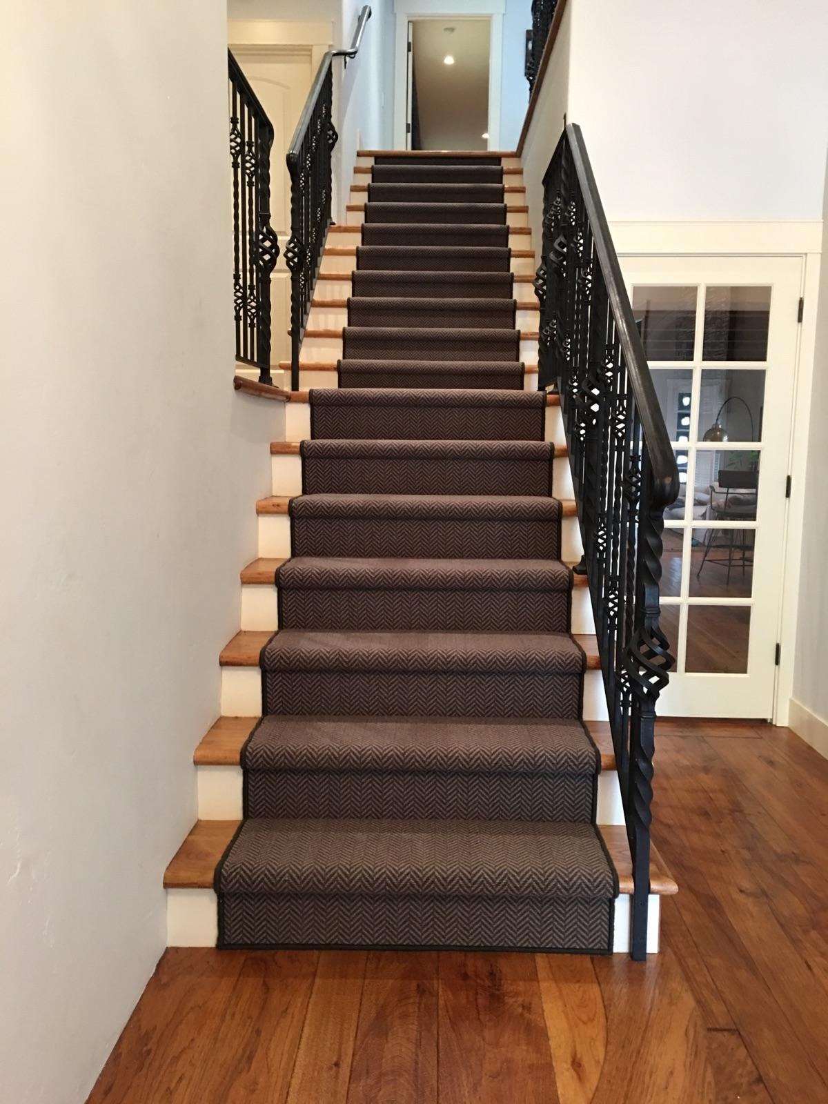 a staircase with a black and white carpet and a black stair case