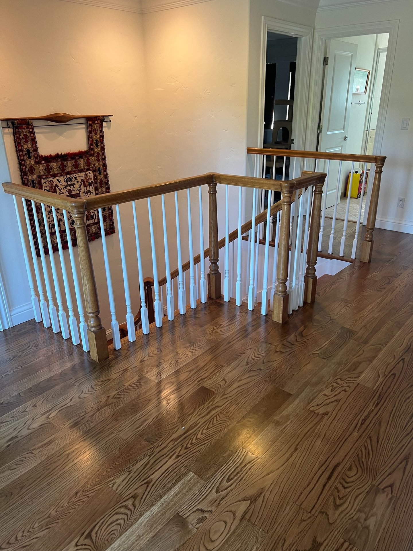 a staircase way with a hardwood floor and a wooden railing