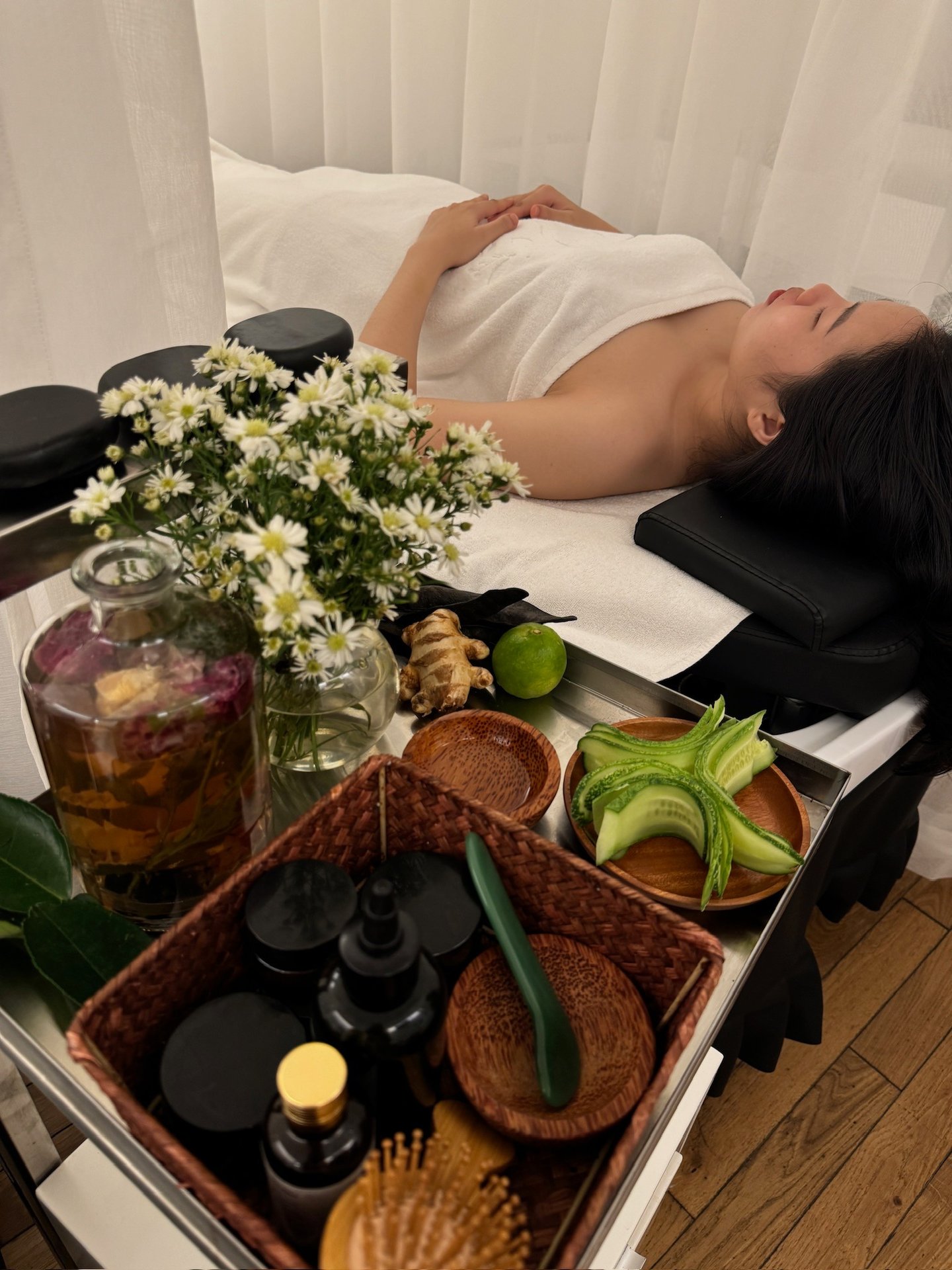 a woman laying on a bed with a tray of hairbrushes