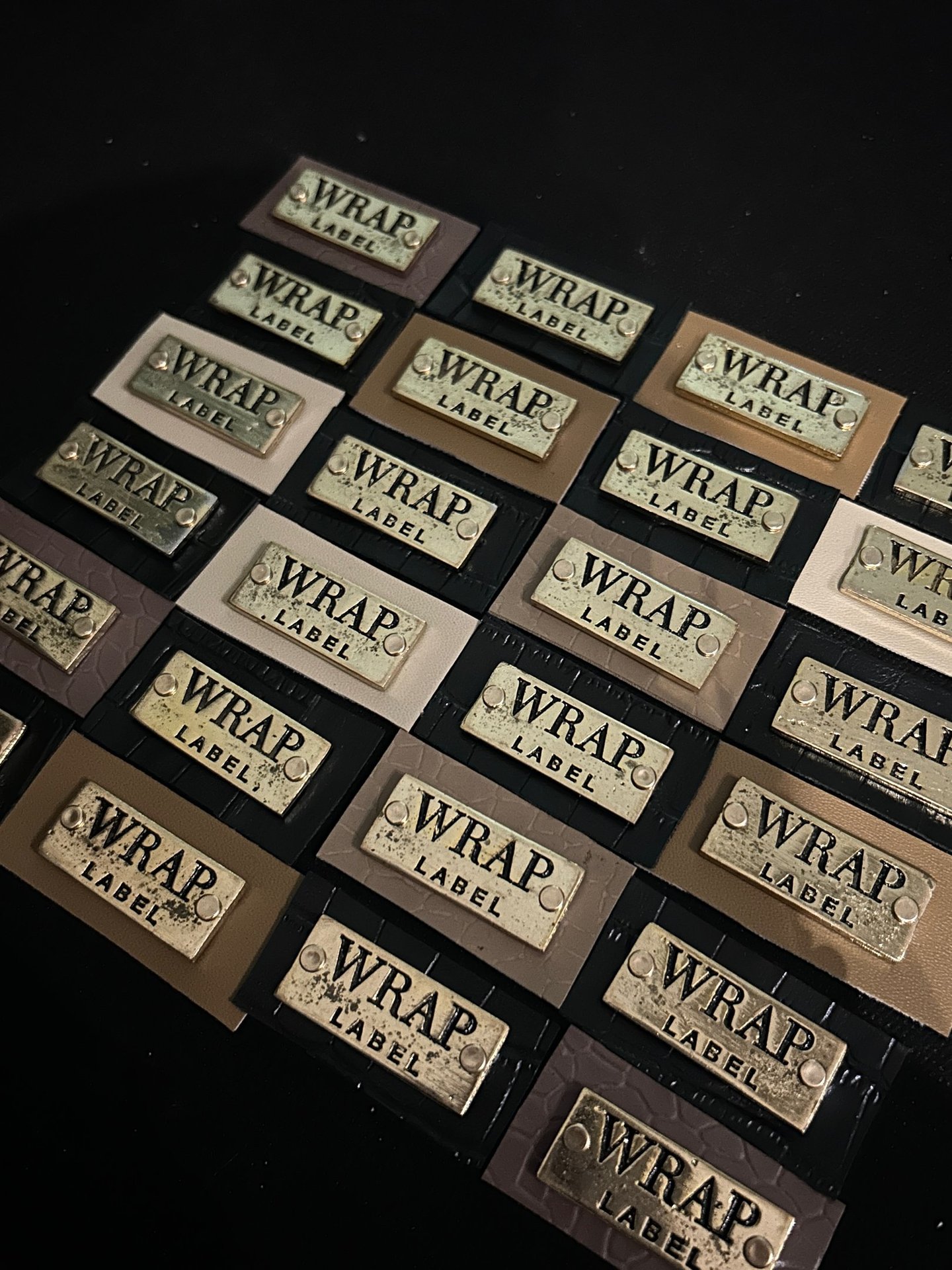 a bunch of leather and metallic labels that read "WRAP Label"