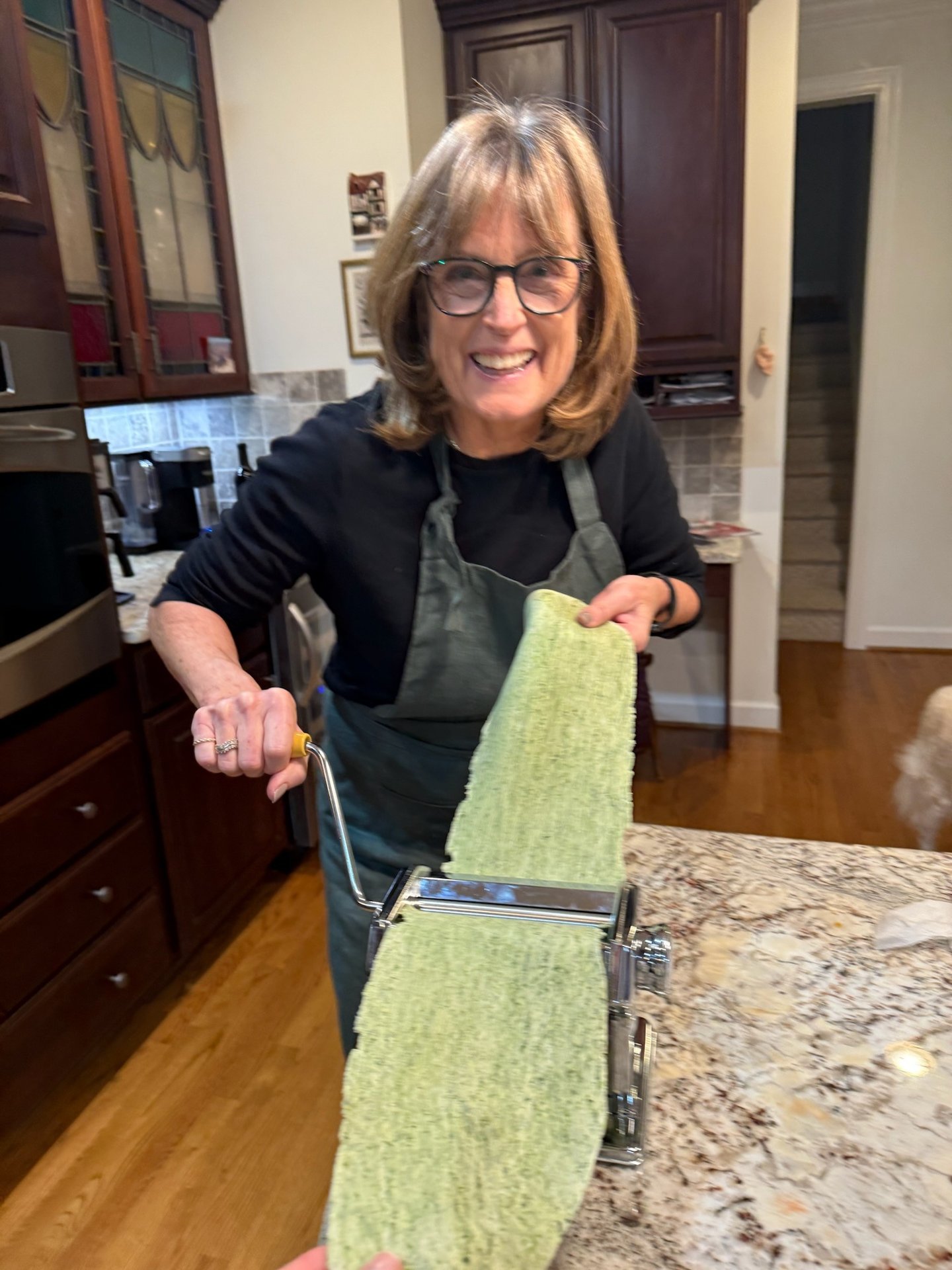 Class participant hand rolling spinach pasta noodle