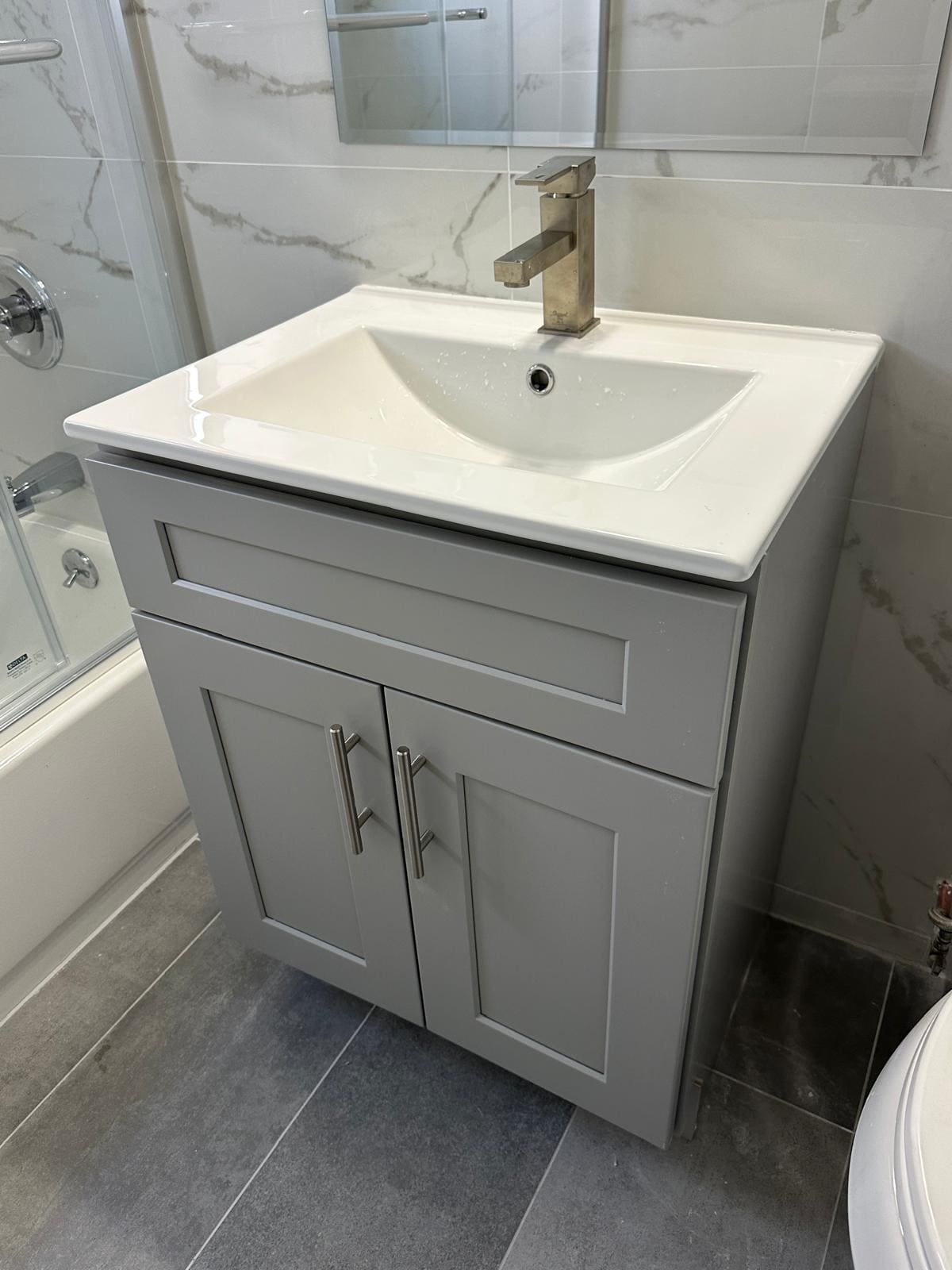 a bathroom sink with a white sink and a shower