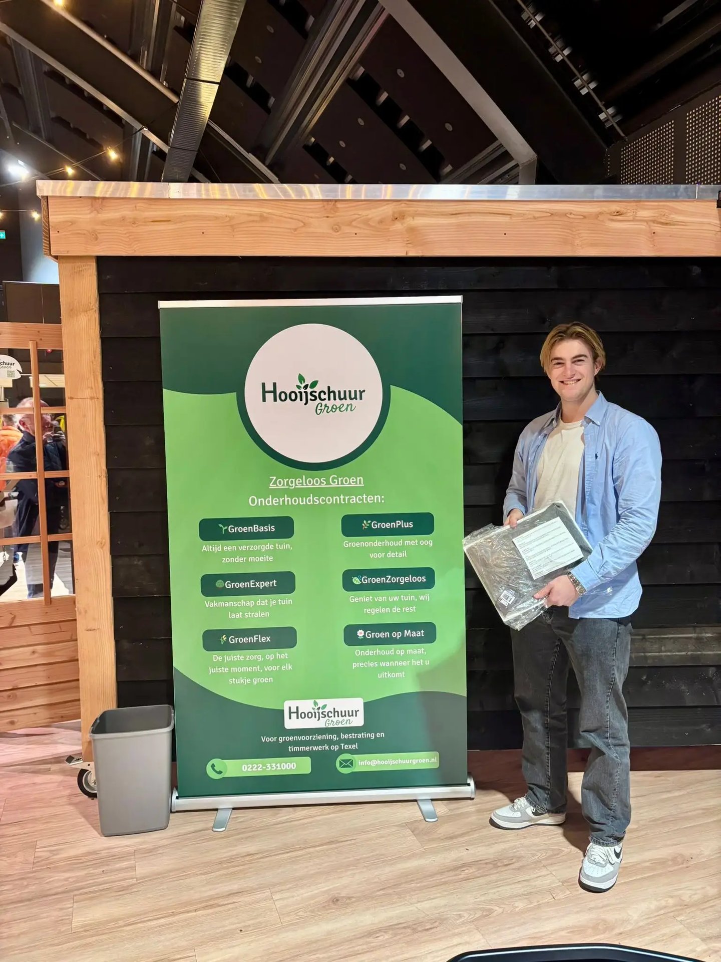 Jelle de Porto naast een banner van Hooijschuur groen