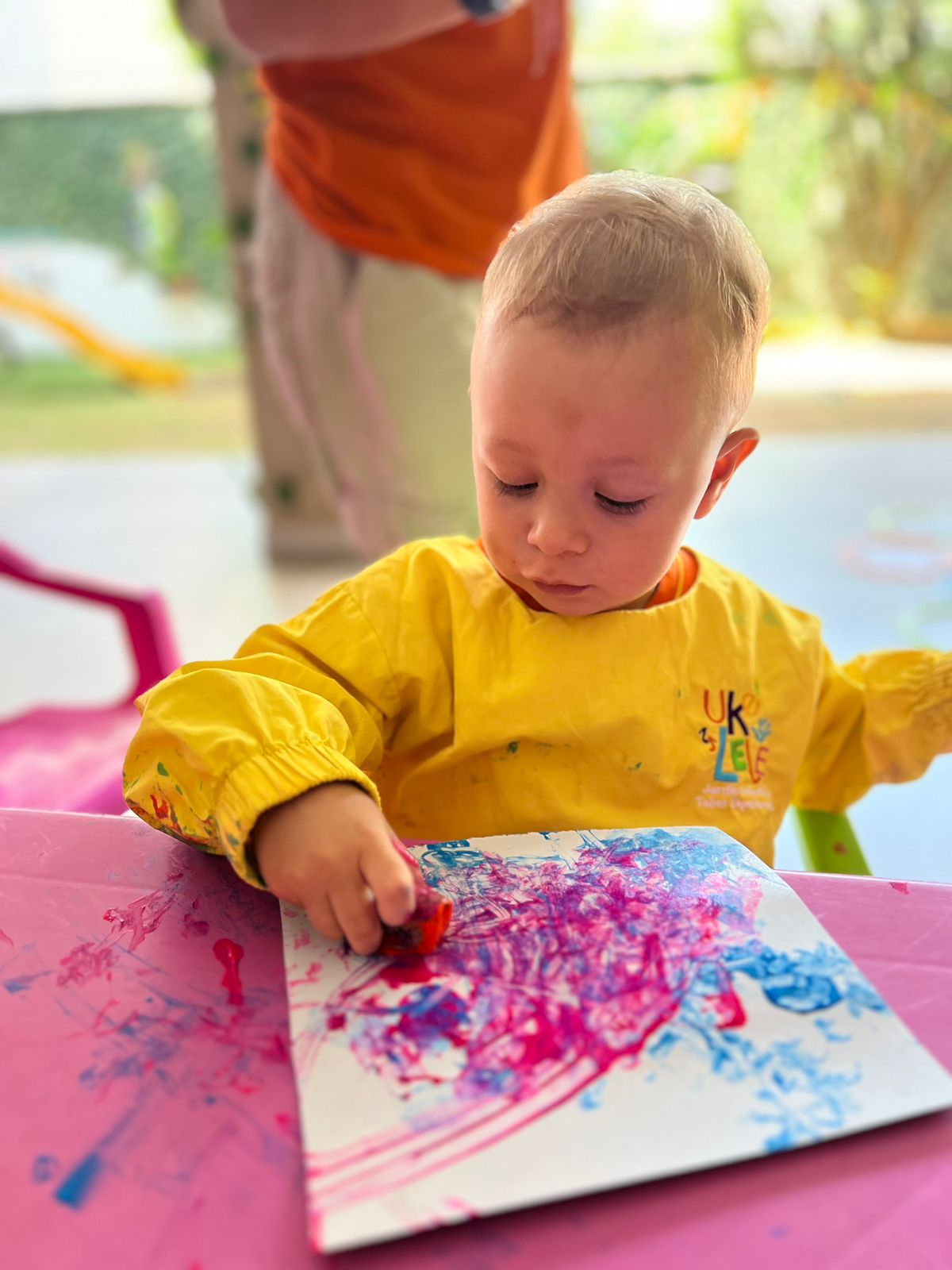 Niño pintando con crayolas en papel blanco