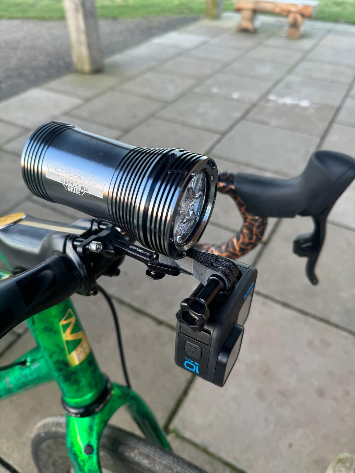 Exposure Six Pack front bike light and GoPro Hero 10 mounted on bicycle handlebars for night riding.