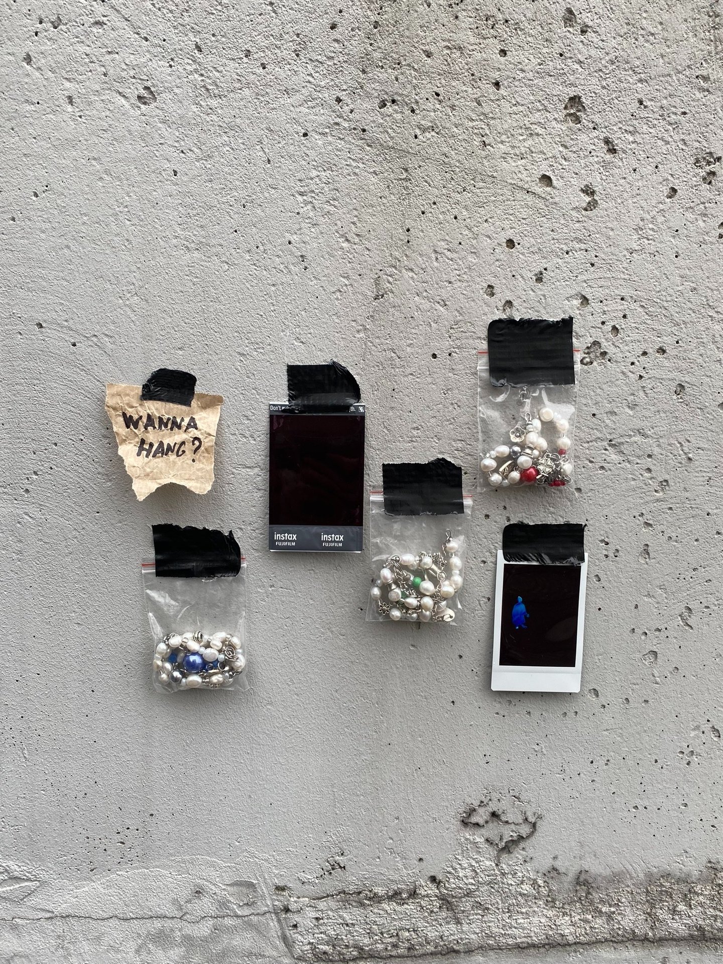 fun.arc.ik. necklaces in zip-lock bags on a concrete wall product picture