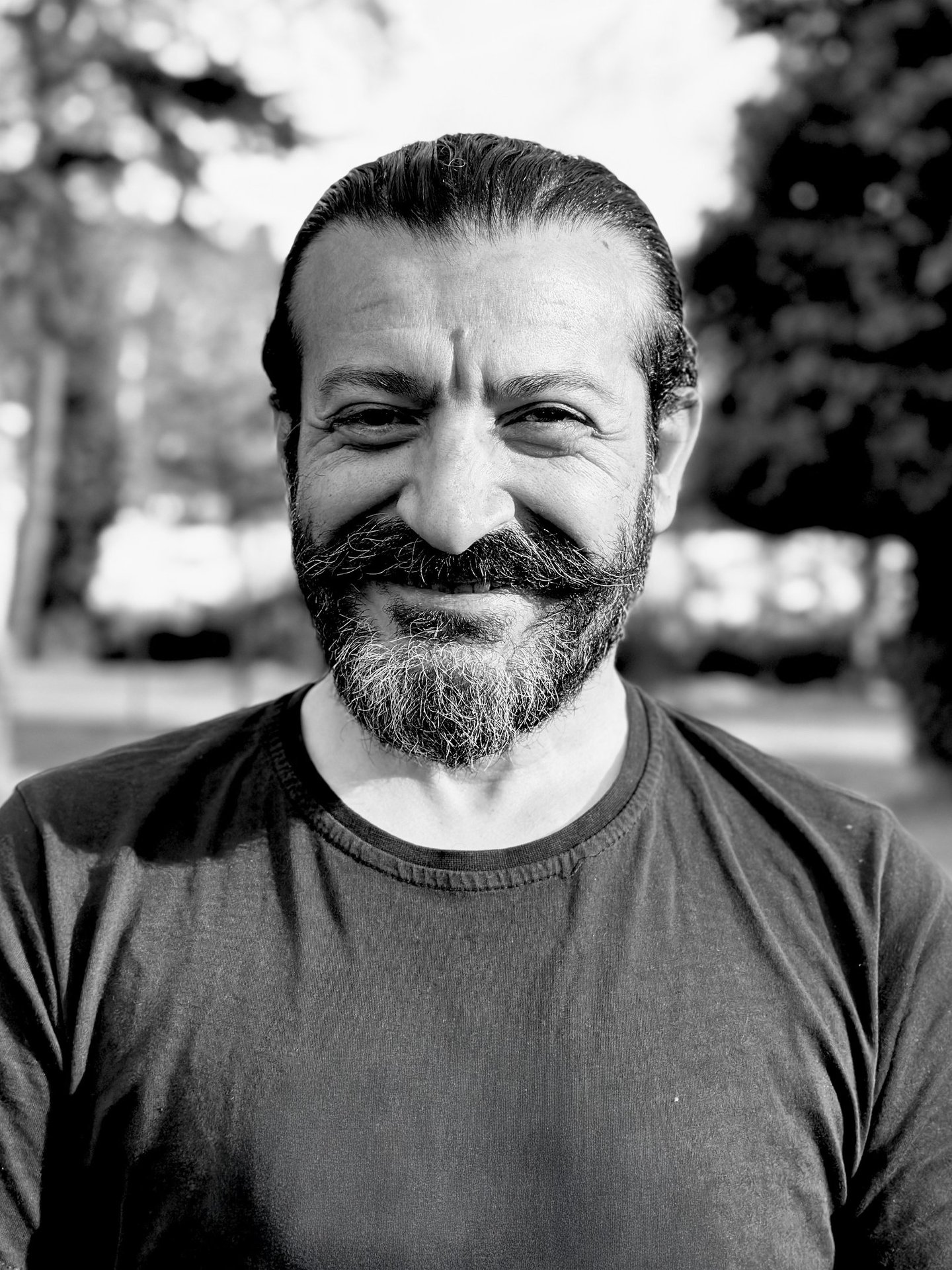 Mehmet Başkak, Tai Ji and Wudang Sword instructor of WDP Turkey, smiling outdoors in black shirt.