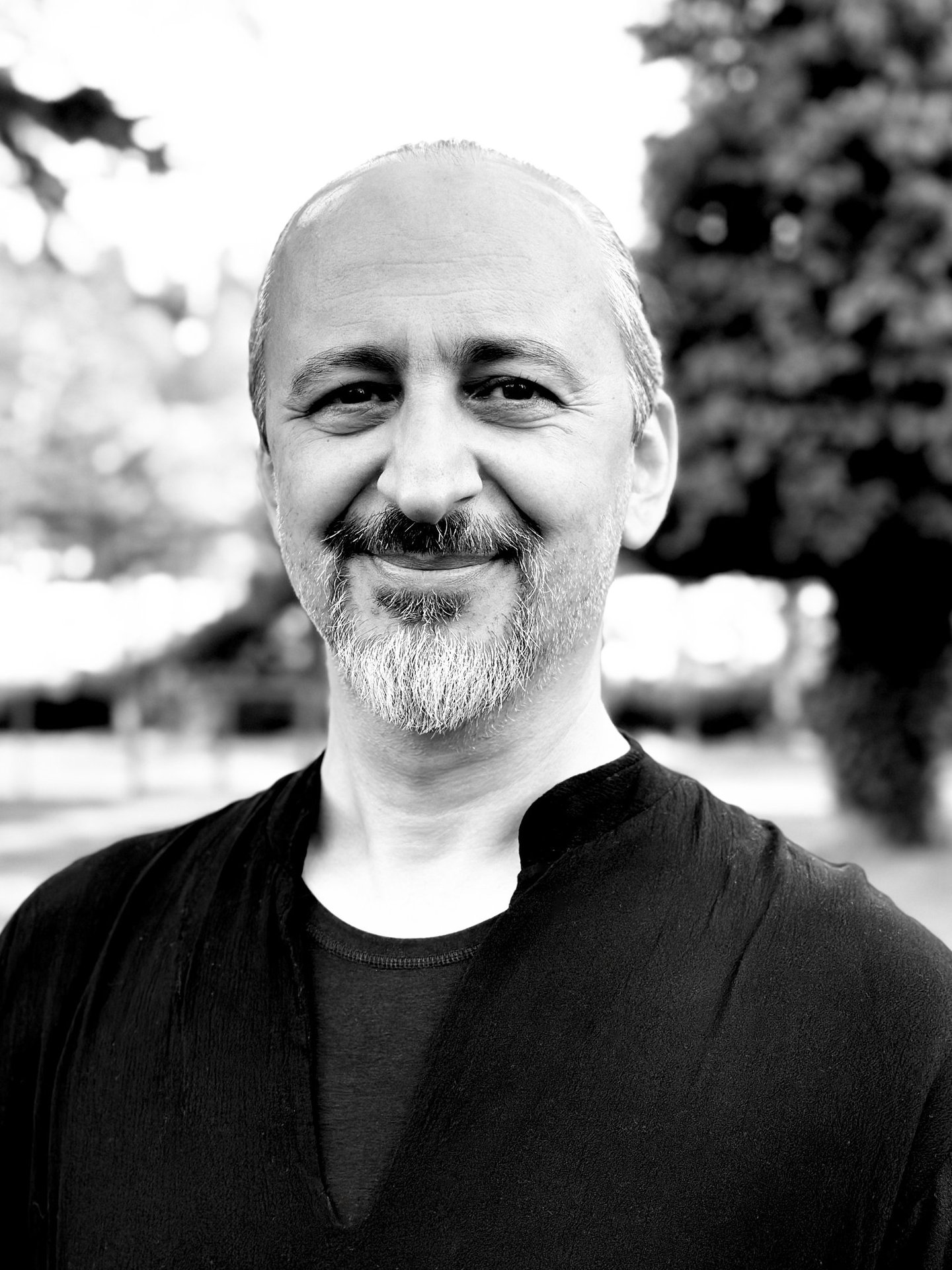 Ugur Tirpan Tai Ji Qi Gong instructor of WDP Turkey, smiling outdoors in black shirt