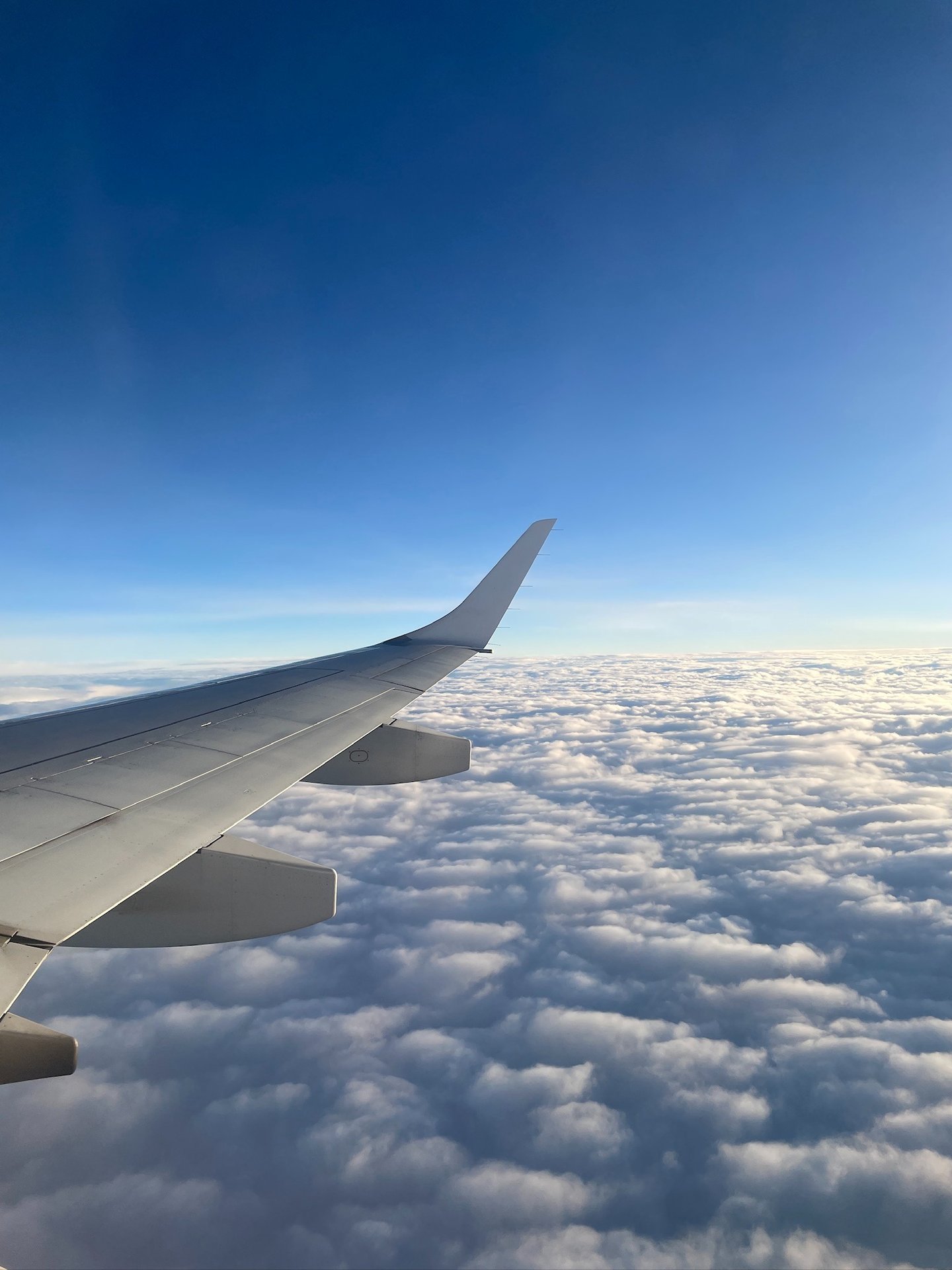 a view of a wing of a plane above the clouds