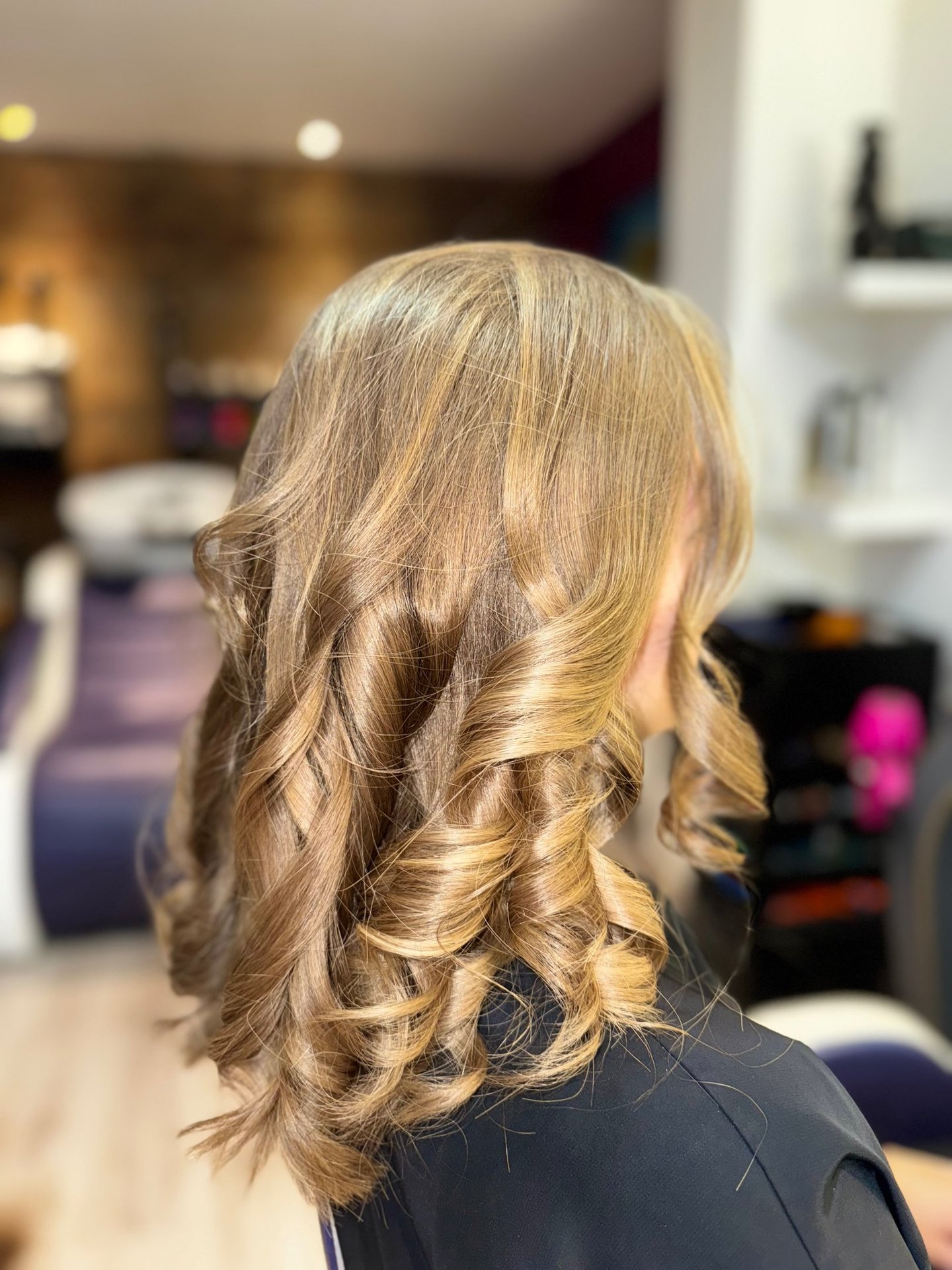 Une femme aux cheveux blonds portant un haut noir.