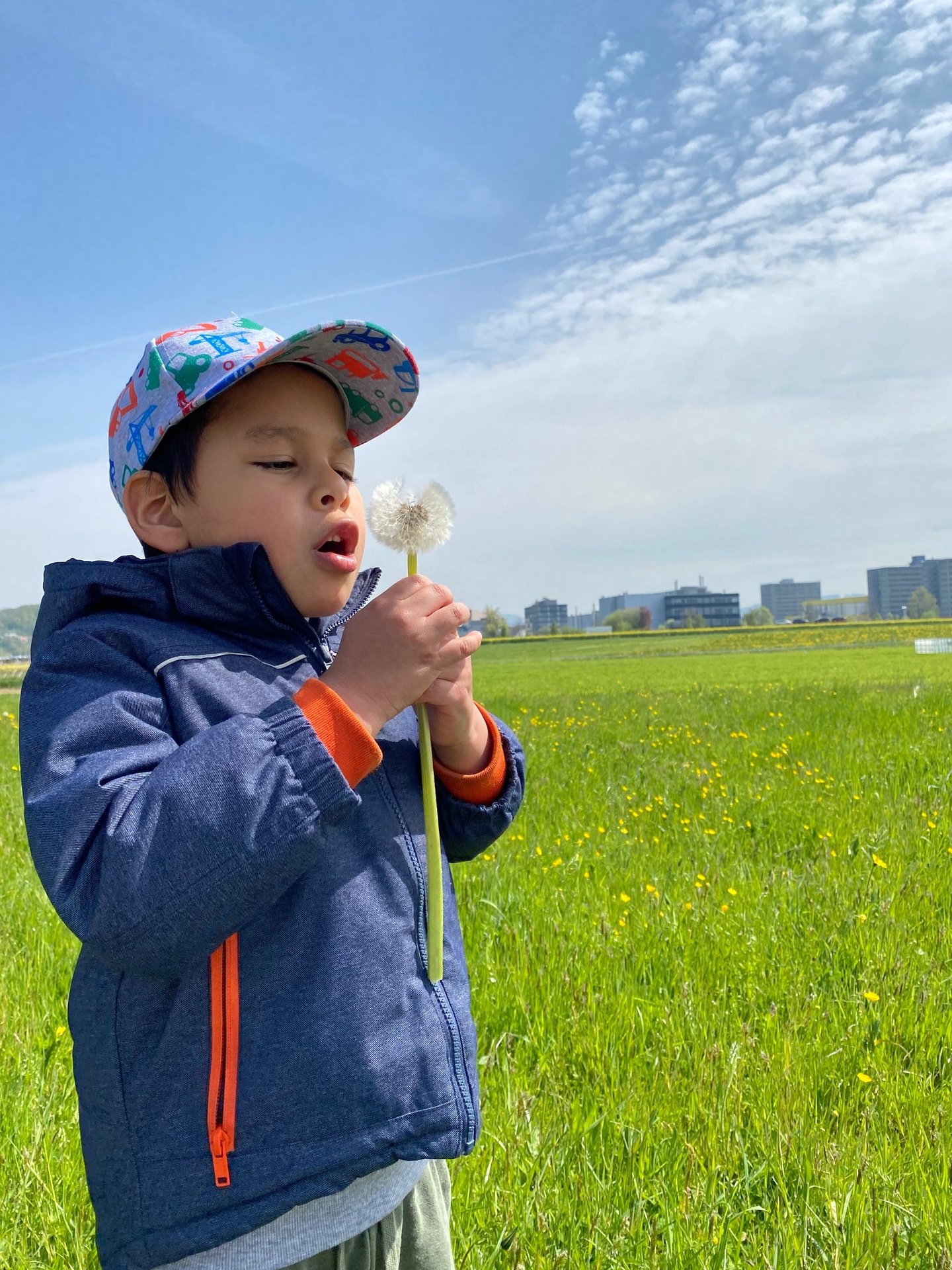 a young boy in a blue jacket and a hat