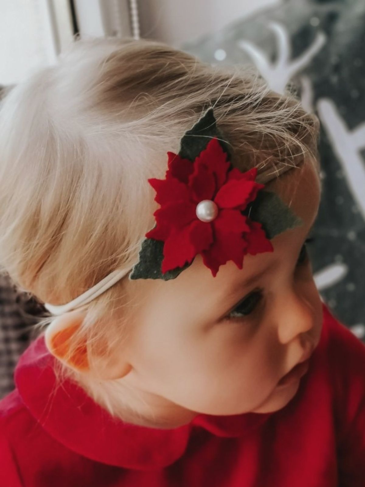 dziewczynka z czerwonym kwiatem na głowie