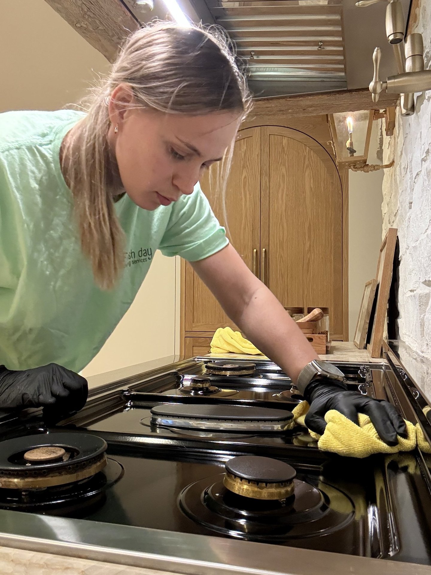 A professional cleaner expertly cleans the cooktop