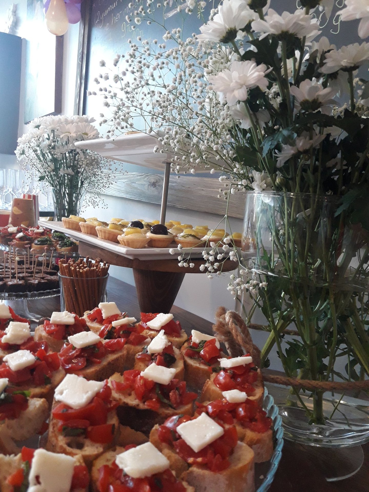 üzerinde kanepe, petifür (petit four), kraker ve tartolet bulunan masa