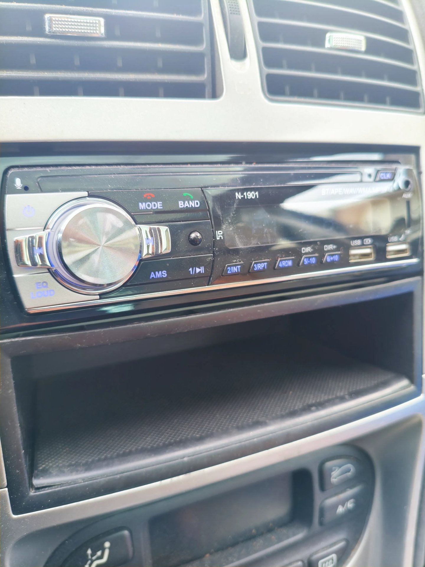 Análise de acabamento e relevo do botão de volume cromado no auto-rádio N-1901 visto de lado.