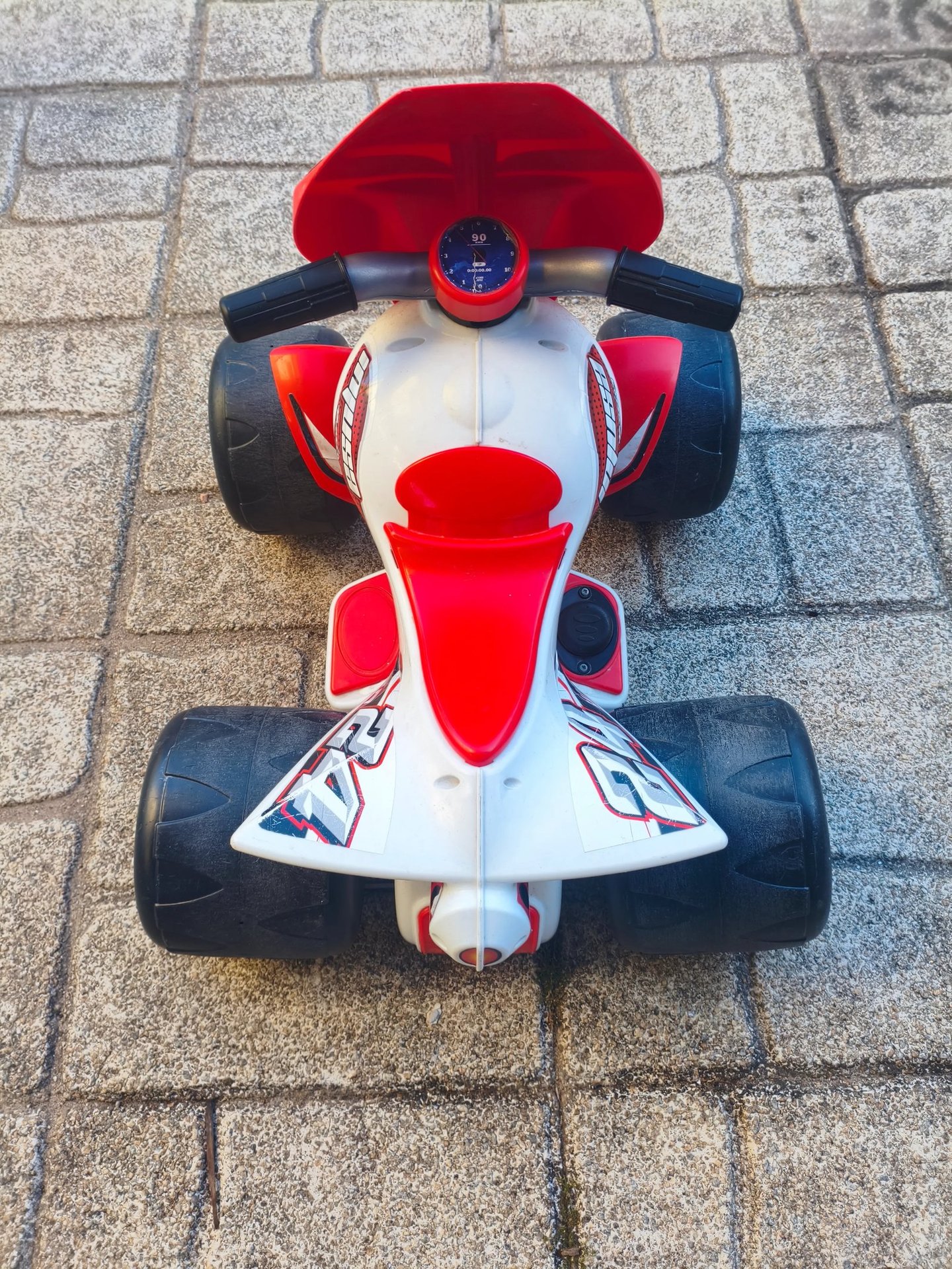 Vista de cima da Moto 4 elétrica Injusa Wrestler 6V com guiador e assento vermelho visíveis